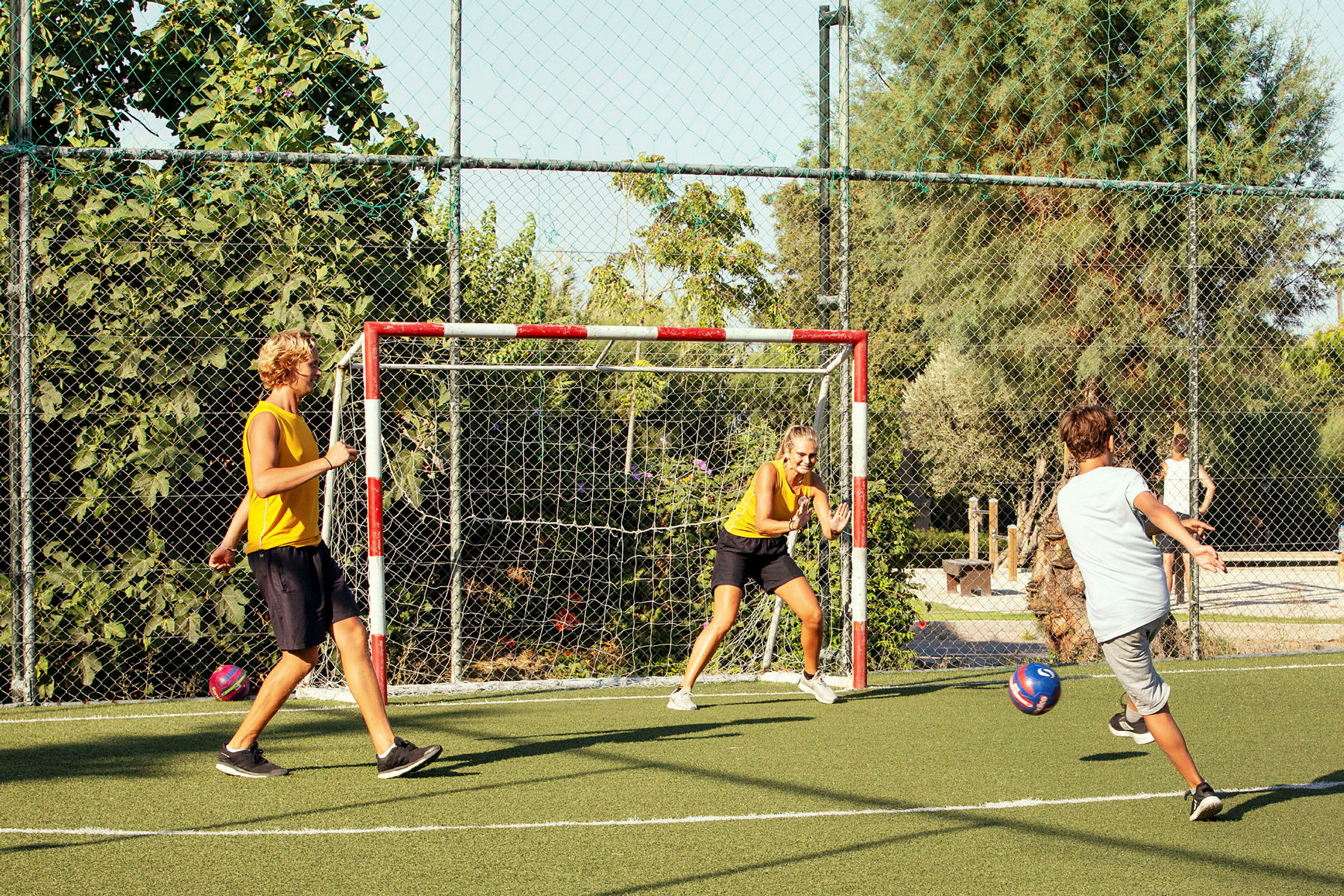 Personer spiller fotball på en bane utendørs. (AI-generert tekst)