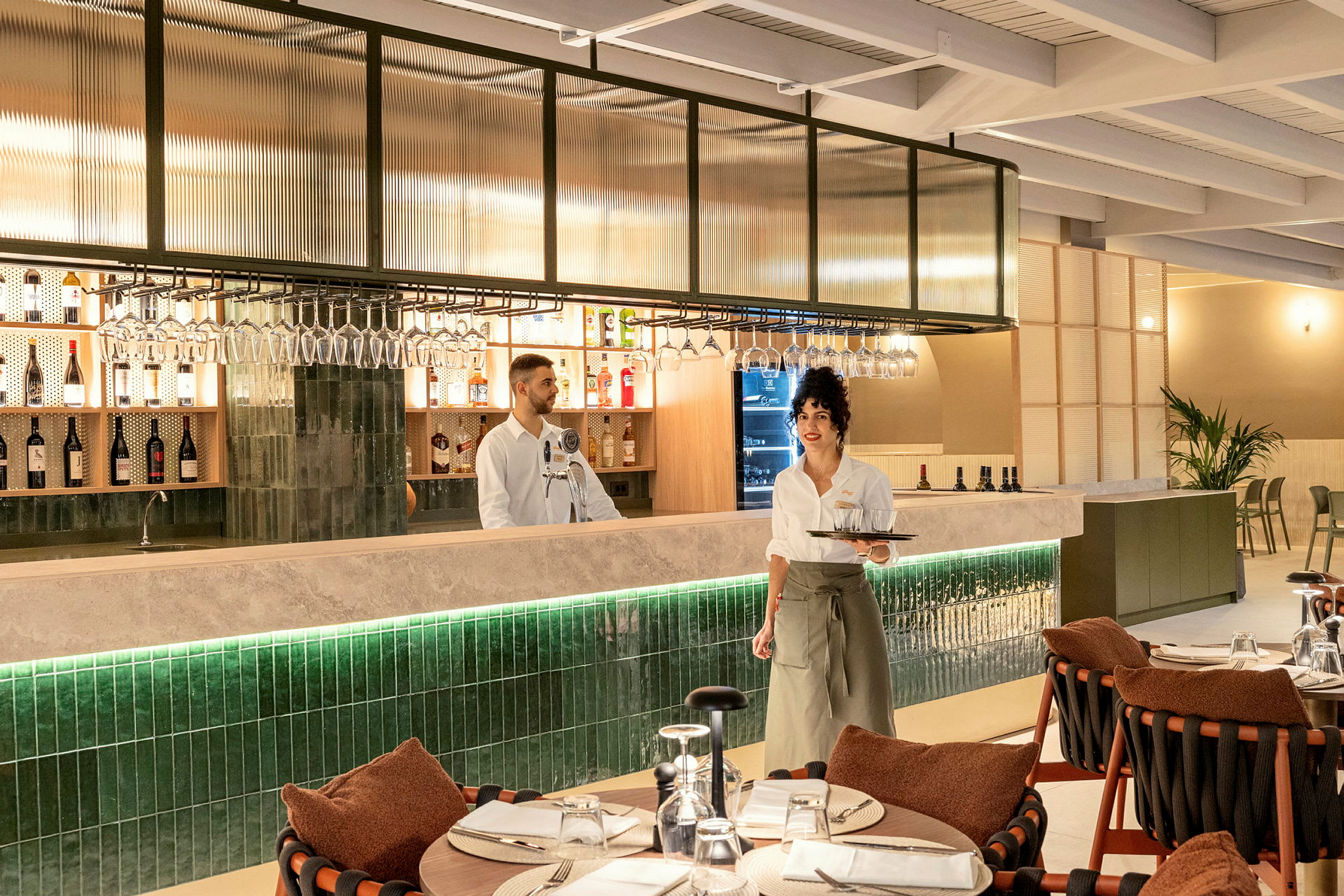 En restaurantinteriør med en bardisk og oppdekkede bord. (AI-generert tekst)