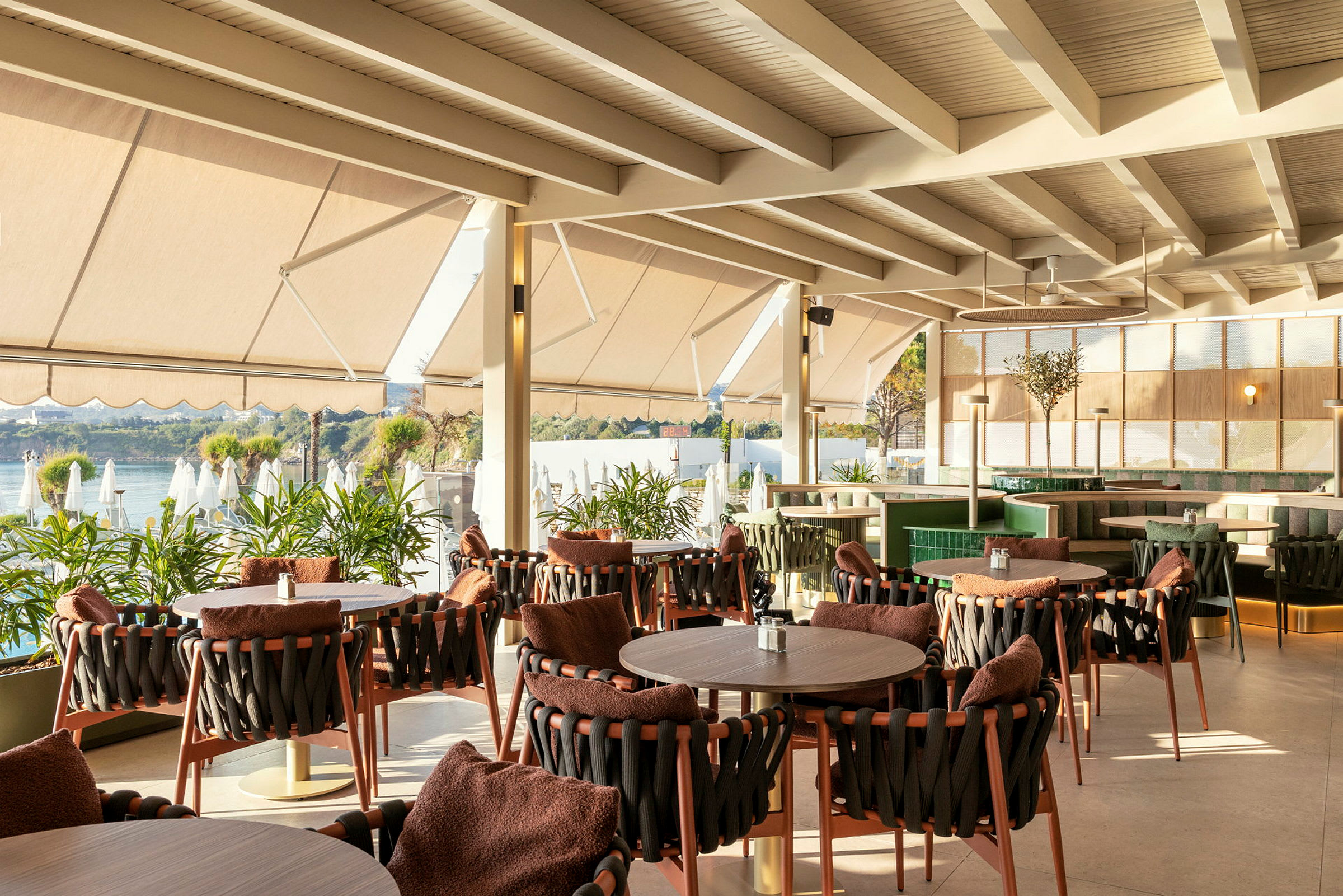 Restaurant med sitteplasser ved vinduet og utsikt over vannet. (AI-generert tekst)
