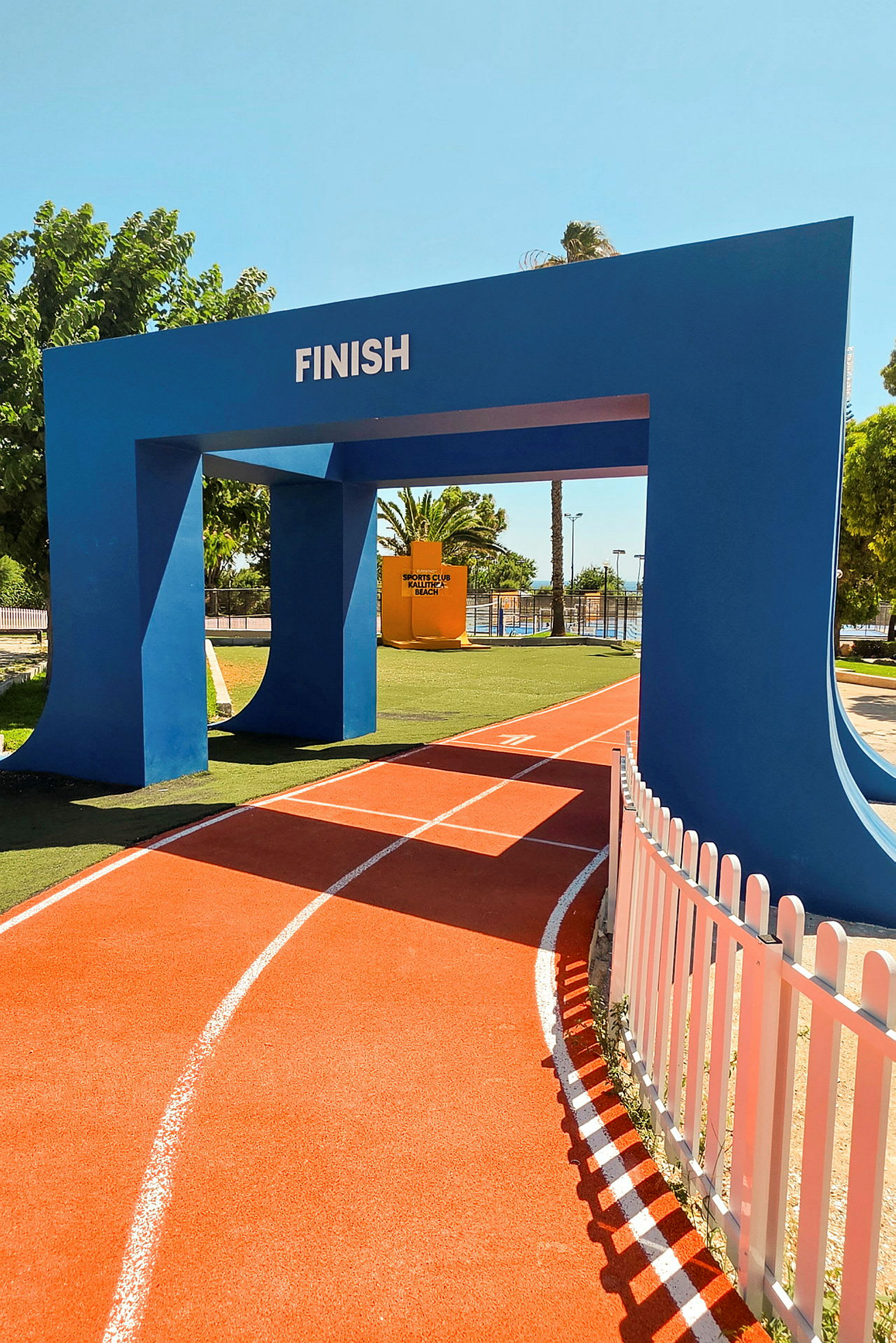 En blå mållinjeport med teksten "FINISH" over en oransje løpebane med hvite linjer. (AI-generert tekst)