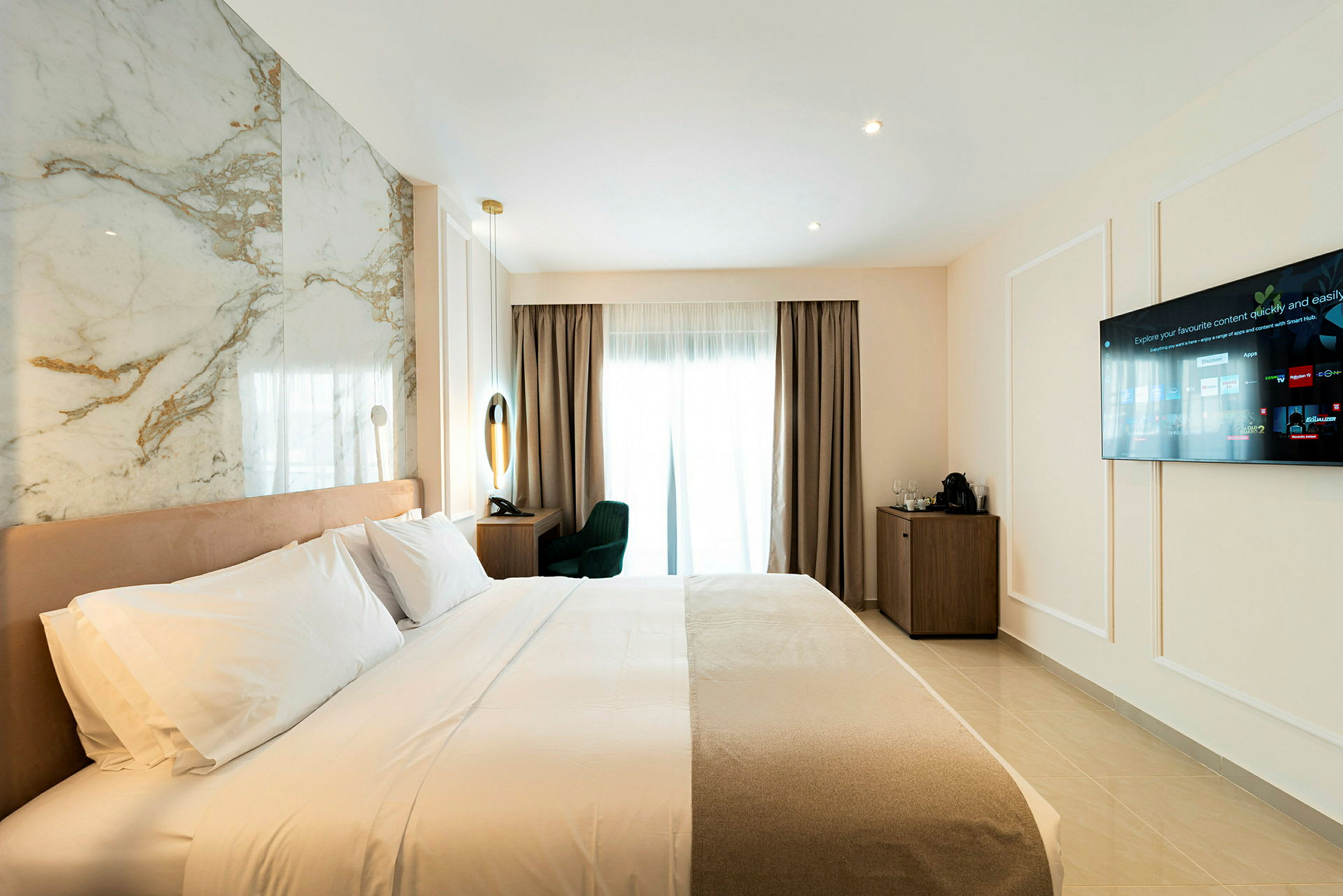 Hotellrom med oppredd seng, vegg-TV og skrivebord nær et vindu. (AI-generert tekst)