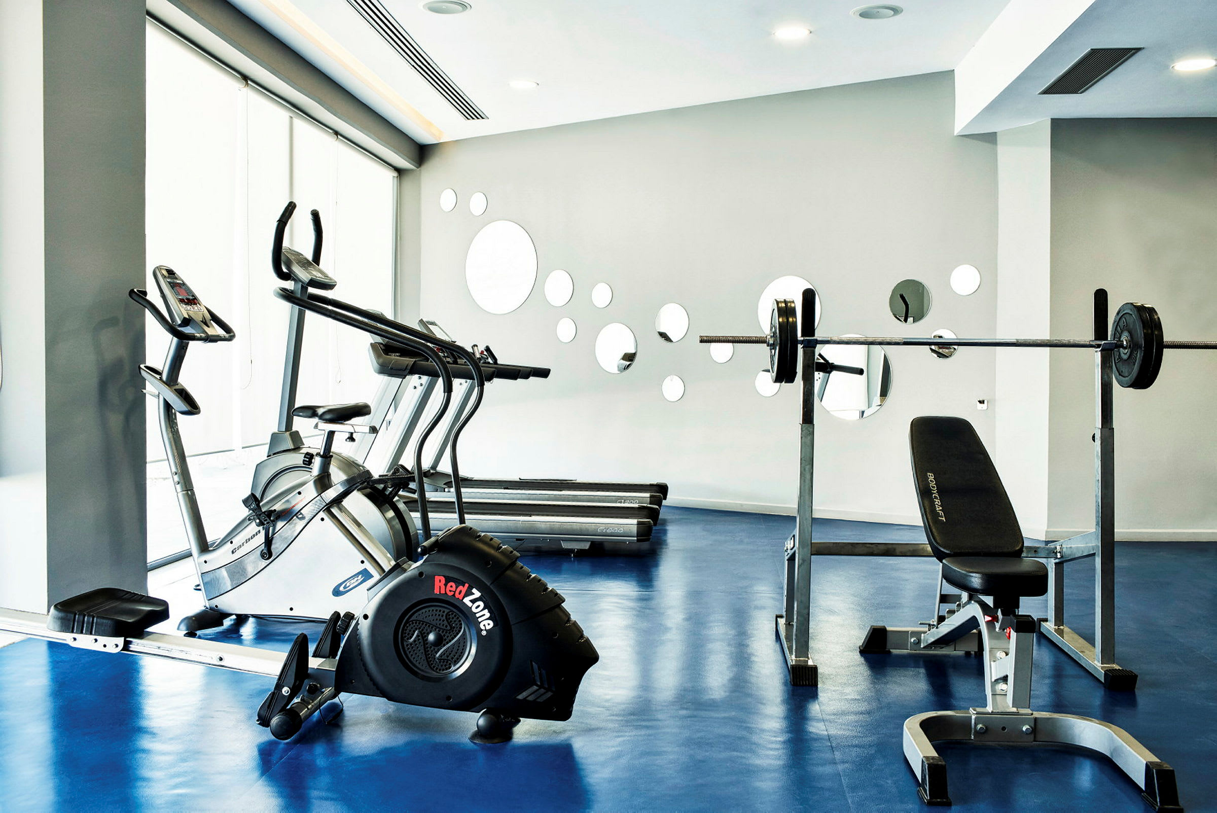 Gym med treningsmaskiner som tredemølle og styrketreningsutstyr. (AI-generert tekst)