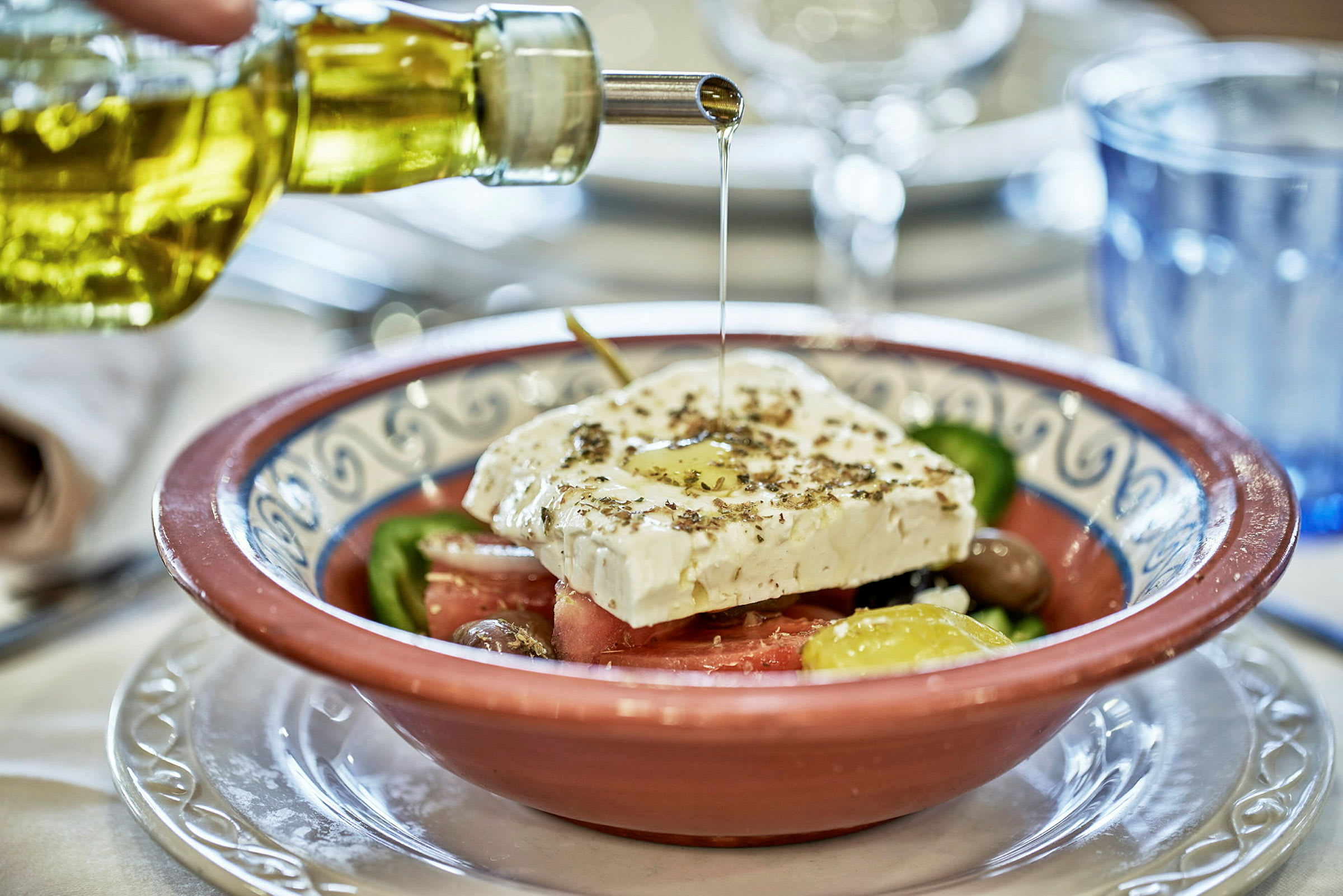 En bolle med gresk salat, toppet med fetaost og olivenolje. (AI-generert tekst)