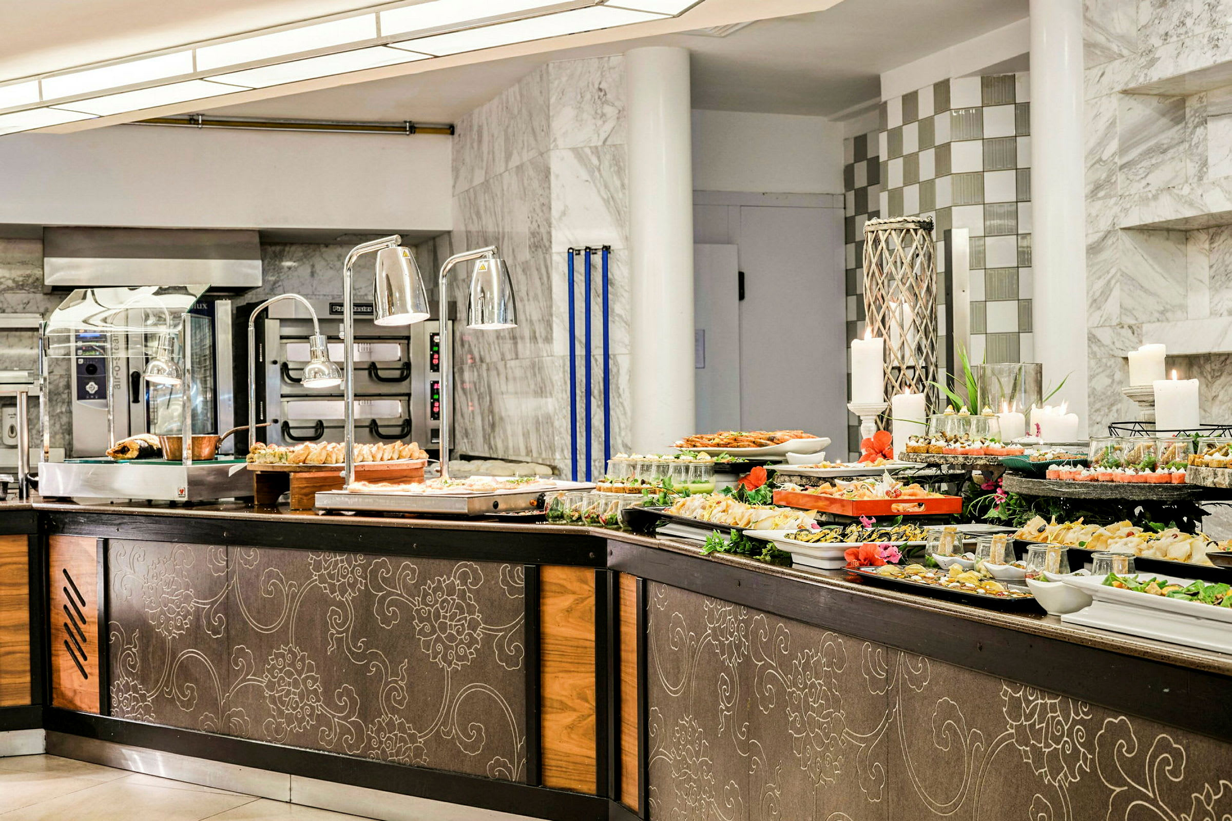 Buffetbord med forskjellige retter i en restaurant med marmordetaljer. (AI-generert tekst)