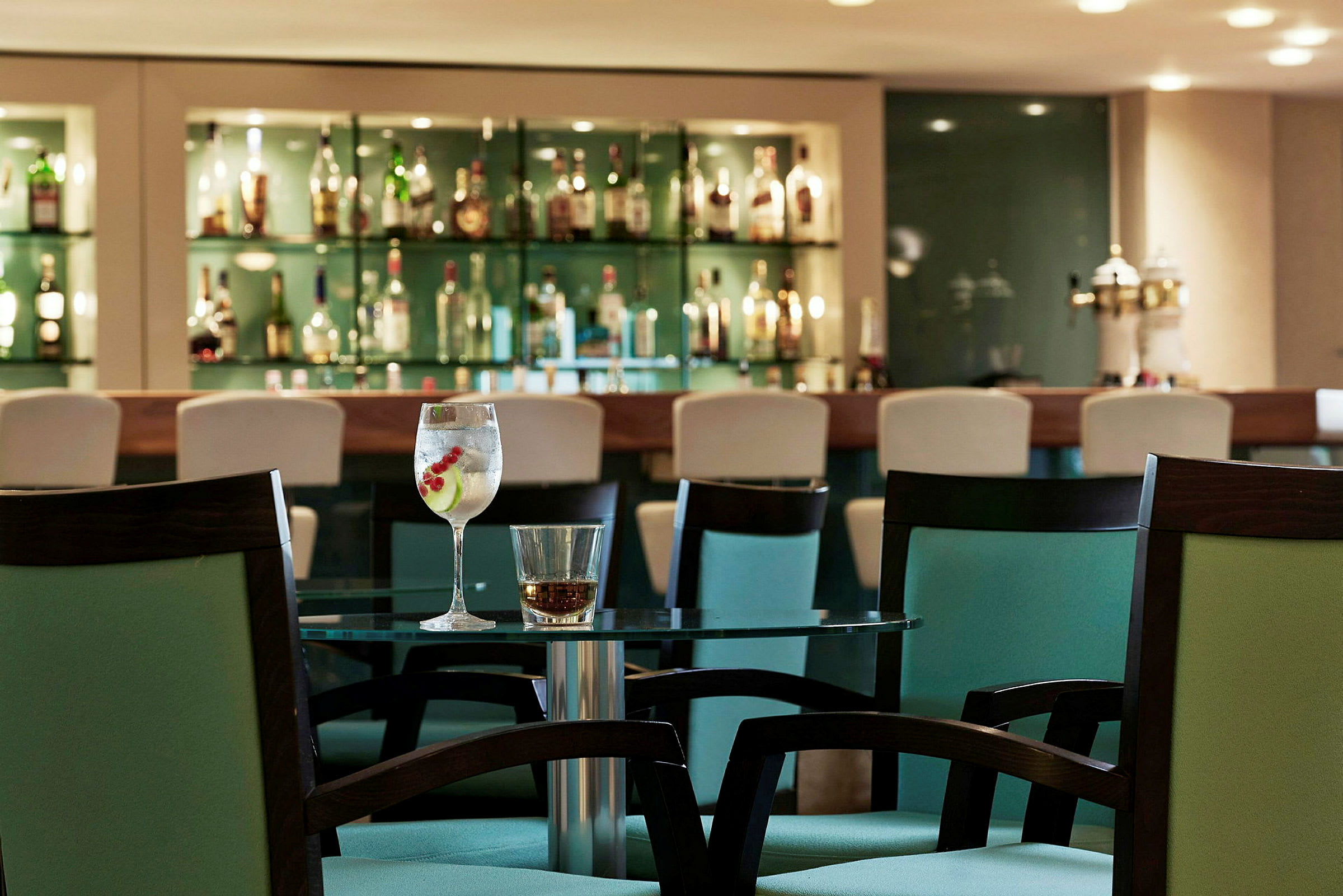 Et bord med to glass foran en bar. (AI-generert tekst)