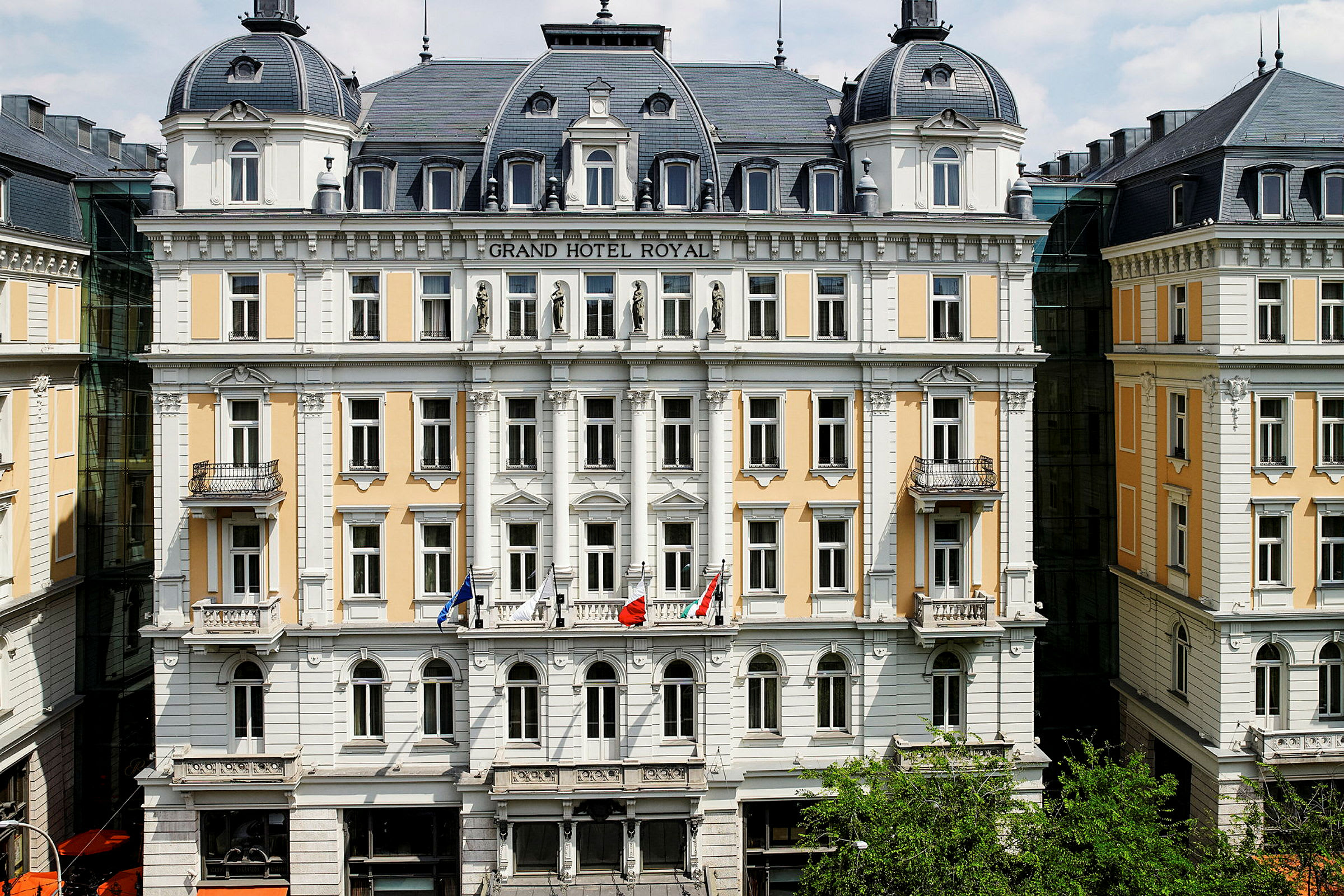 Bilde av fasaden til et historisk hotell med flere etasjer i klassisk stil. (AI-generert tekst)