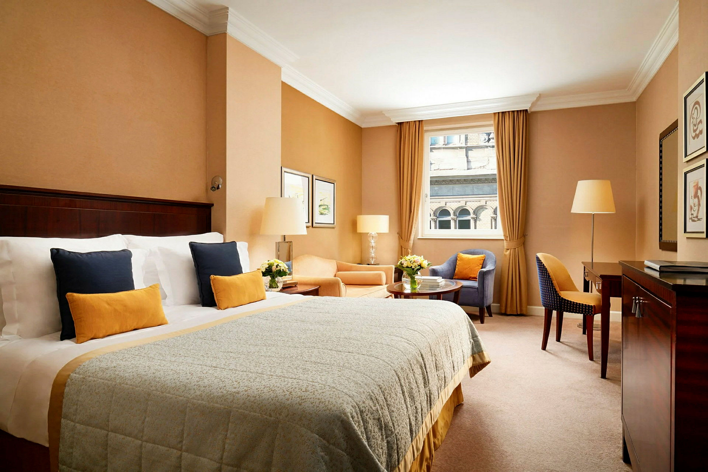 Et elegant hotellrom med en bred seng, sittegruppe og vindu med utsikt. (AI-generert tekst)
