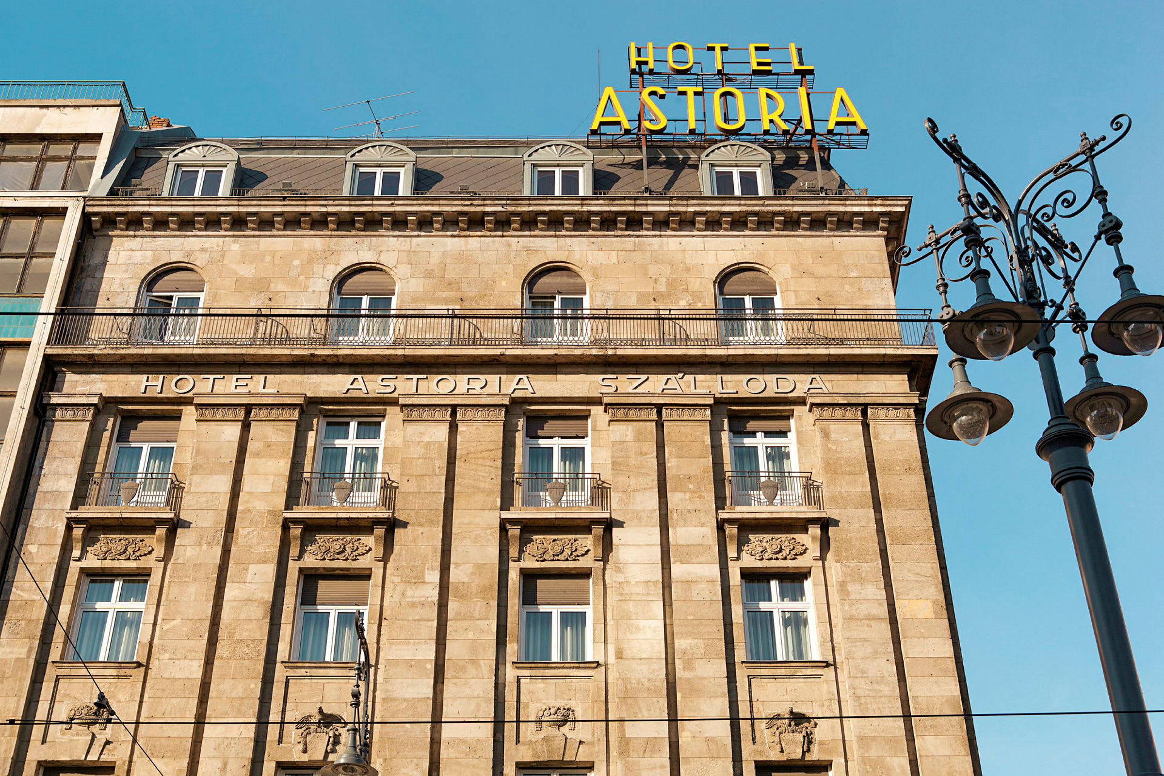 Hotellfasade med navnet "Hotel Astoria" og en gateklynge ved siden av. (AI-generert tekst)