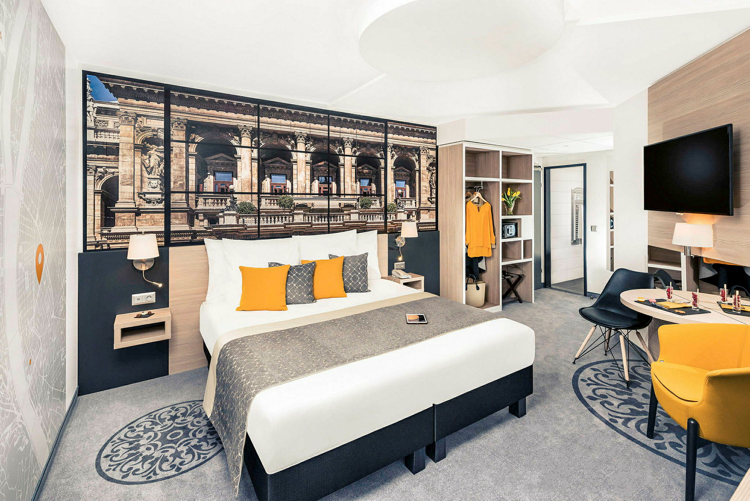 Hotellrom med dobbeltseng, veggdekorasjon, sittegruppe og garderobe. (AI-generert tekst)
