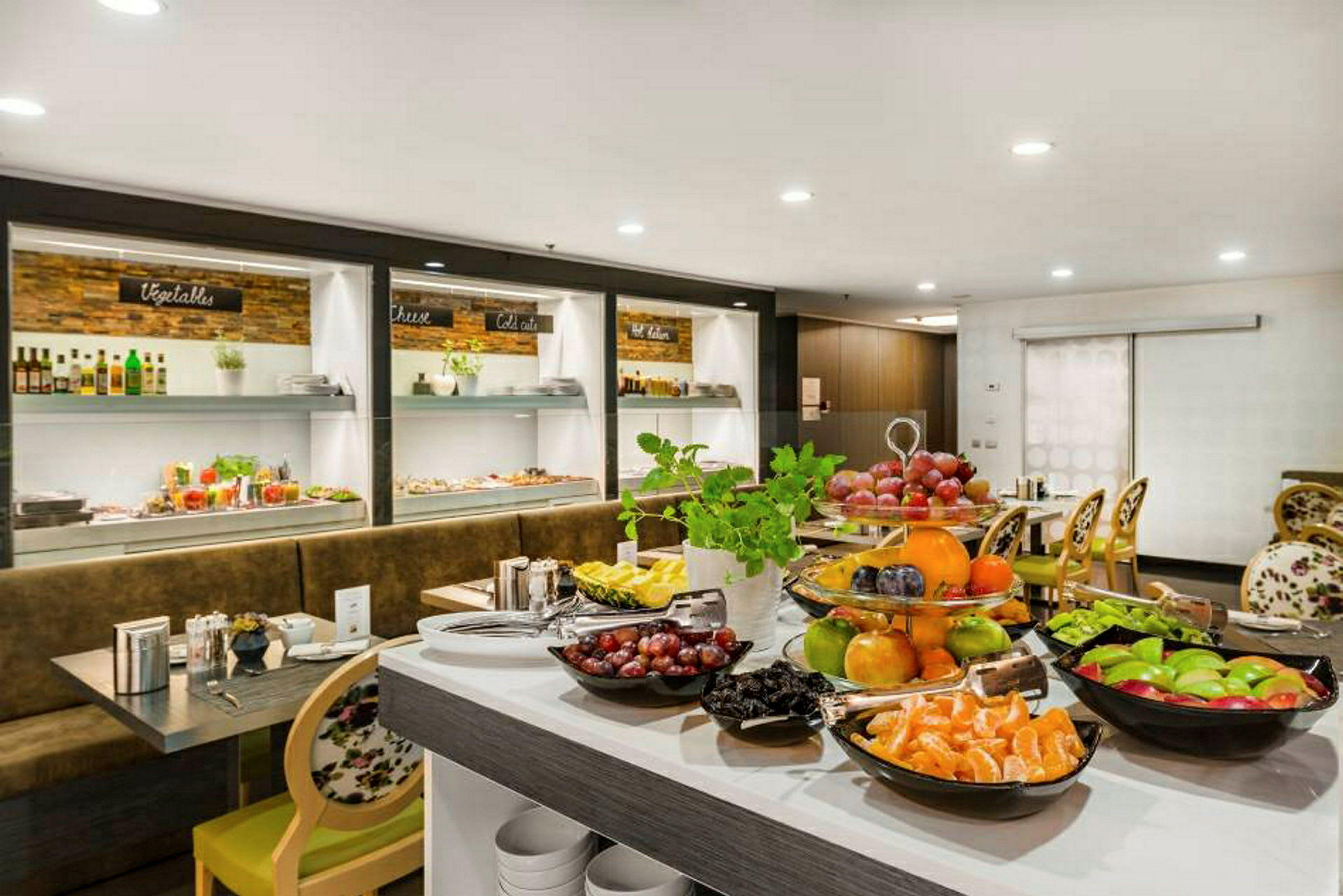 Frukt og mat lagt frem ved en buffet i et spiseområde. (AI-generert tekst)