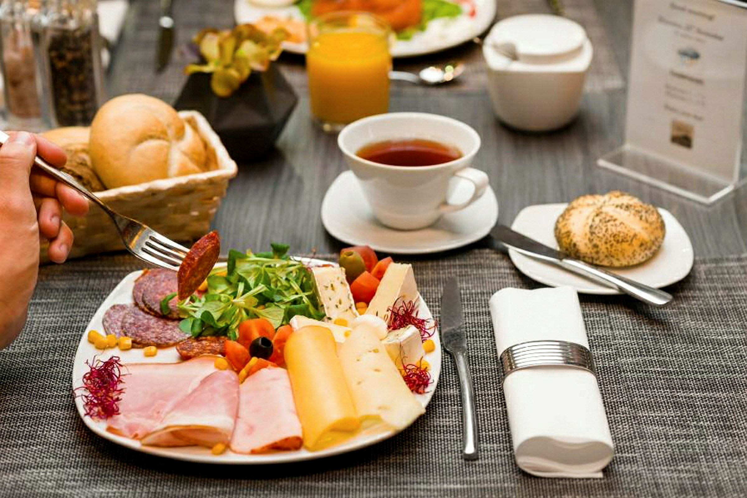 En frokosttallerken med pålegg, ost og grønnsaker. (AI-generert tekst)