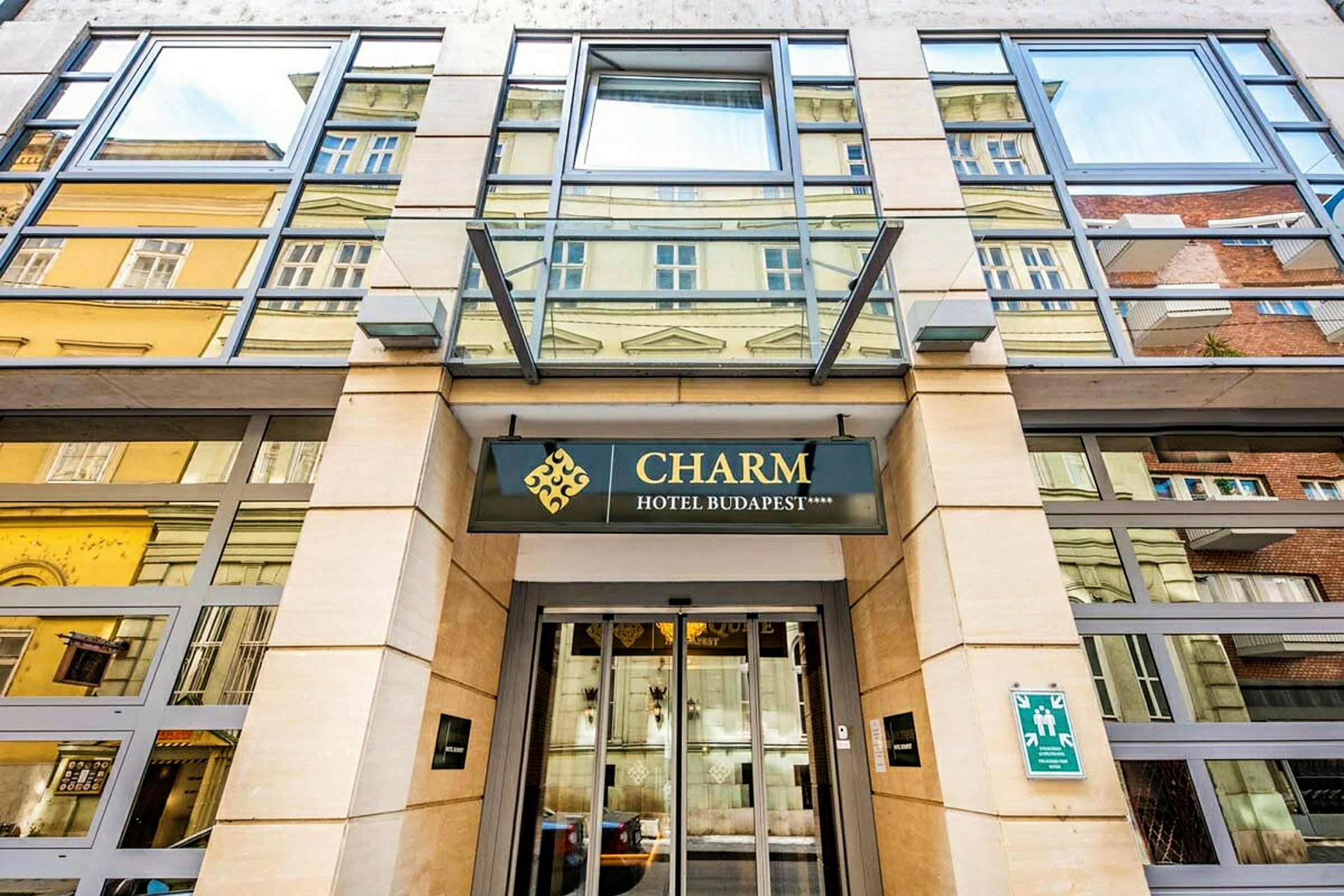 Inngang til et hotell med skiltet "Charm Hotel Budapest". (AI-generert tekst)