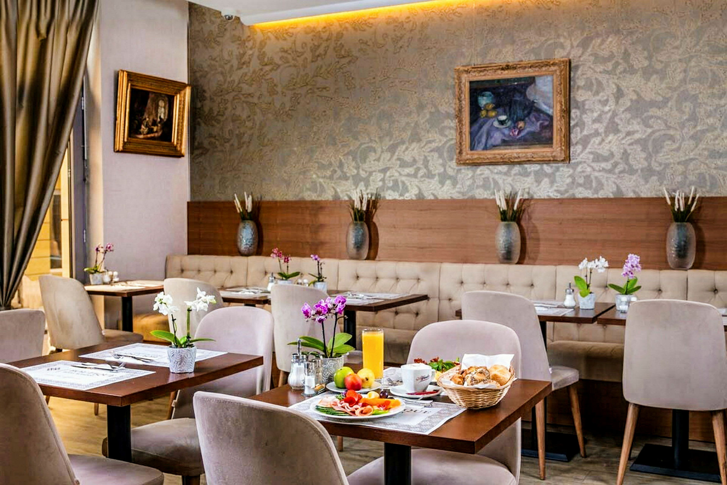 Et stilrent møblert kafé med små bord, stoler og blomster, samt frokost lagt opp på et av bordene. (AI-generert tekst)