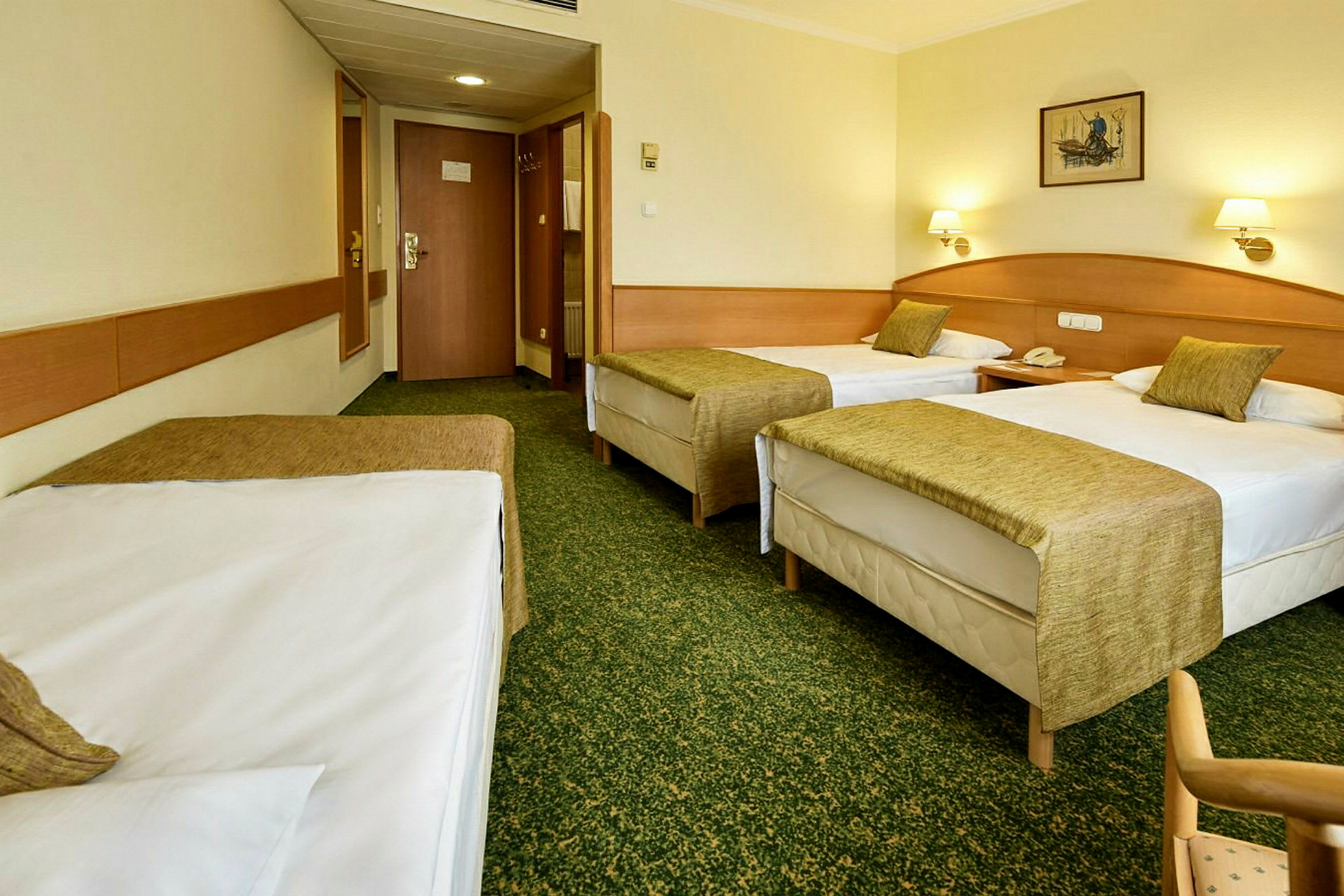 Hotellrom med tre enkeltsenger, grønne sengetepper og lyse vegger. (AI-generert tekst)