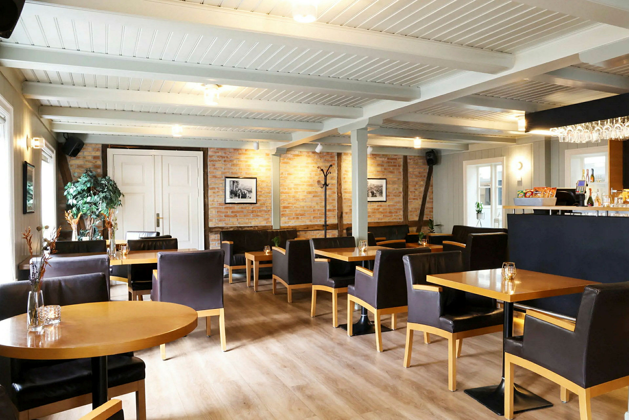 Et bilde av en innendørs restaurant med bord, stoler og en bar. (AI-generert tekst)