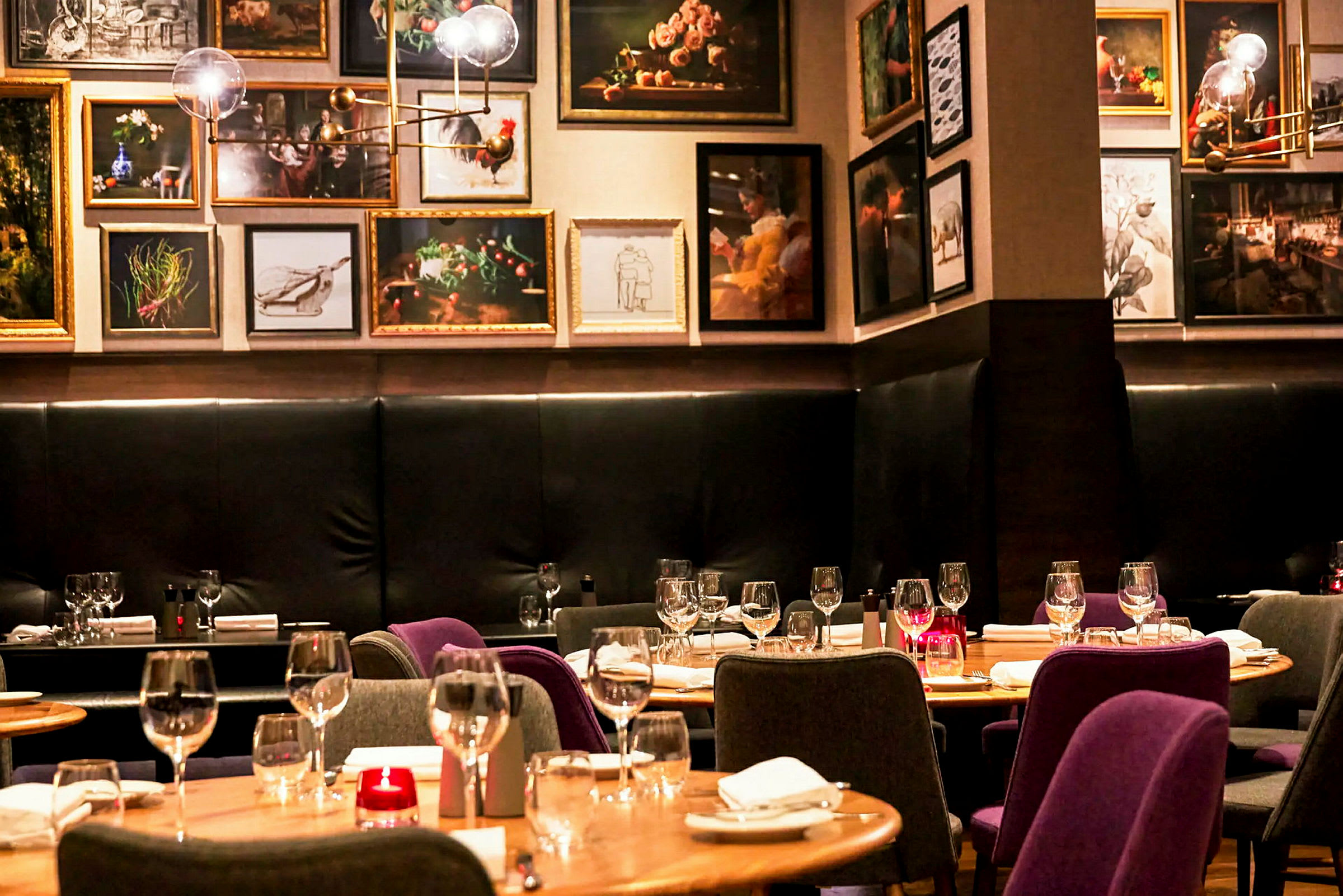 Interiør av en restaurant med dekkede bord og kunstverk på veggene. (AI-generert tekst)