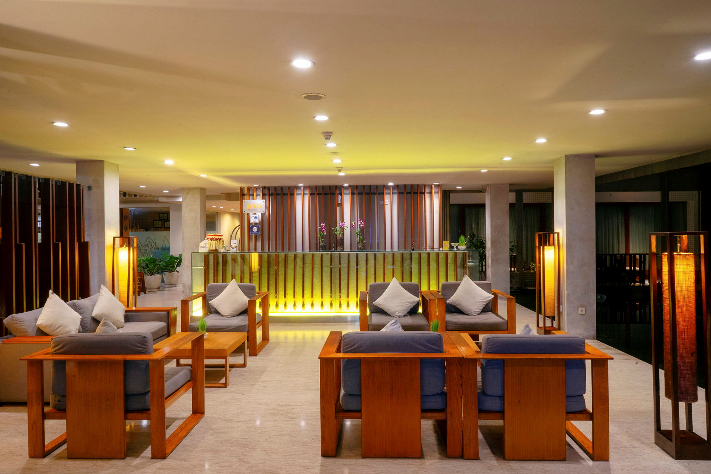 En moderne og godt opplyst hotellobby med tremøbler og komfortable sitteplasser. (AI-generert tekst)