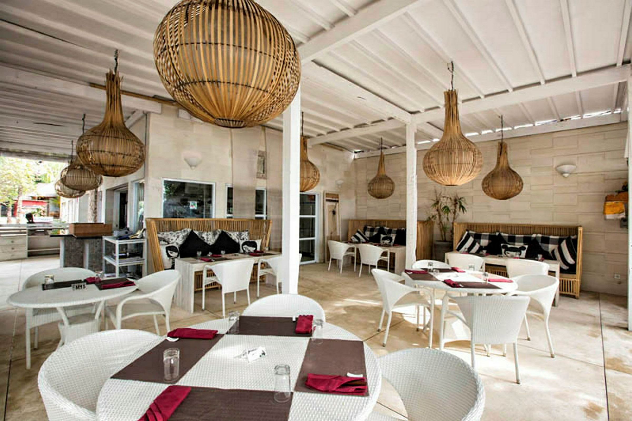 Restaurantområde med hvite bord og stoler samt dekorative lamper i taket. (AI-generert tekst)