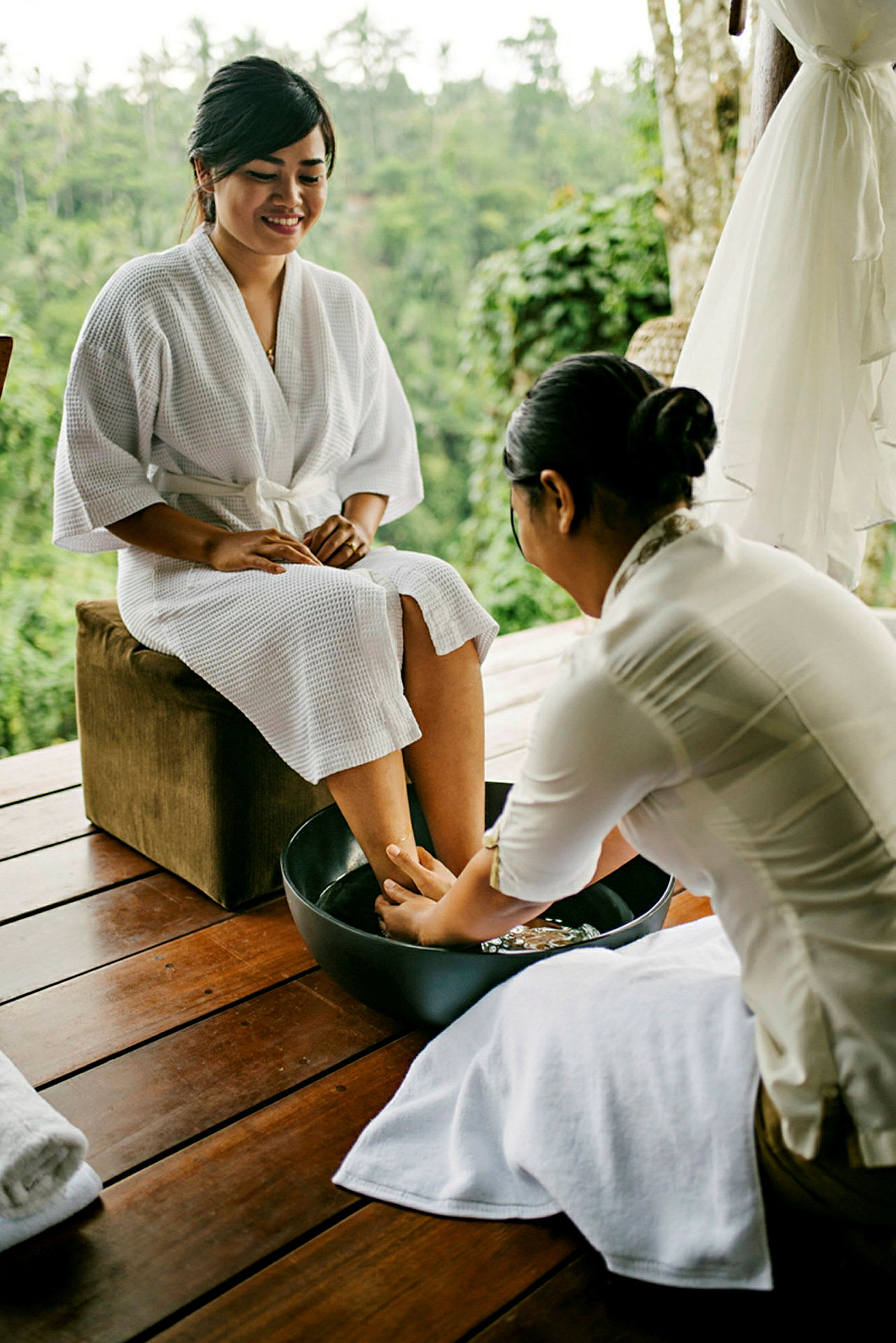 En person som får fotmassasje på et spa-anlegg med natur i bakgrunnen. (AI-generert tekst)