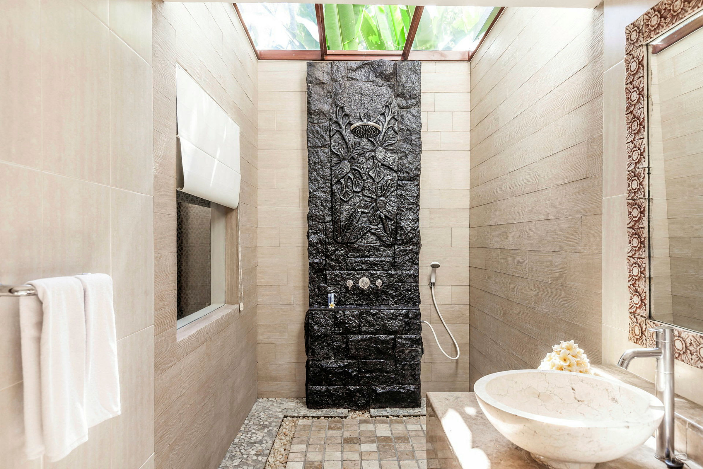 Et moderne bad med en dusj med svart dekorativ steinpanel og en marmorservant. (AI-generert tekst)