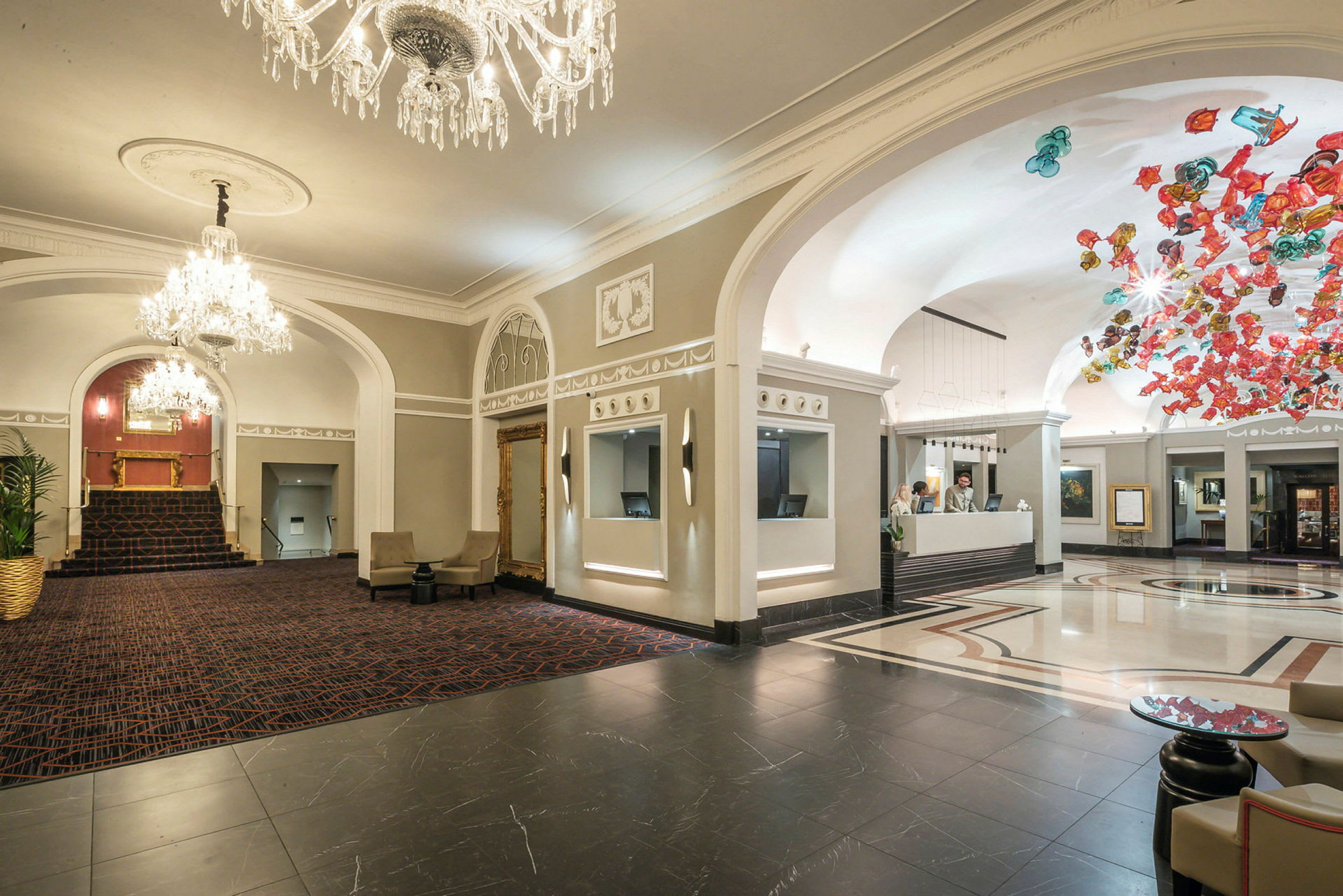 Hotellobby med plass og elegante detaljer, resepsjon til høyre. (AI-generert tekst)