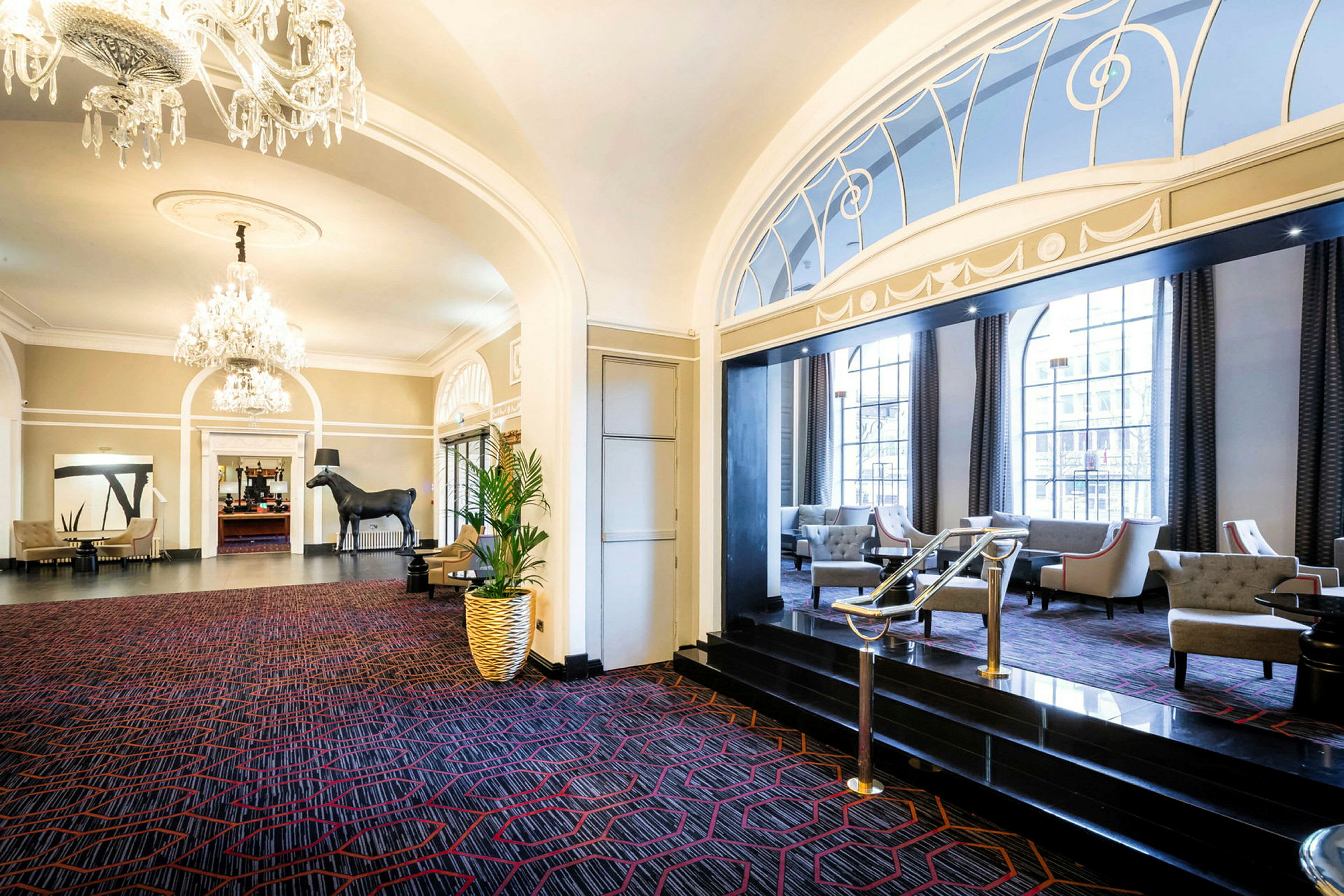 Hotellobbyen med luksuriøse møbler, lysekrone og dekorativ innredning. (AI-generert tekst)