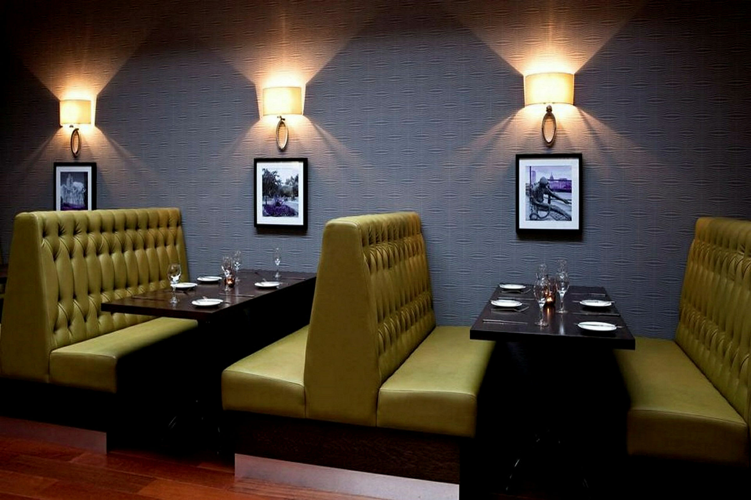 Bilde av en restaurant med sitteplasser i båser. Veggene er dekorert med små bilder og vegglamper. (AI-generert tekst)