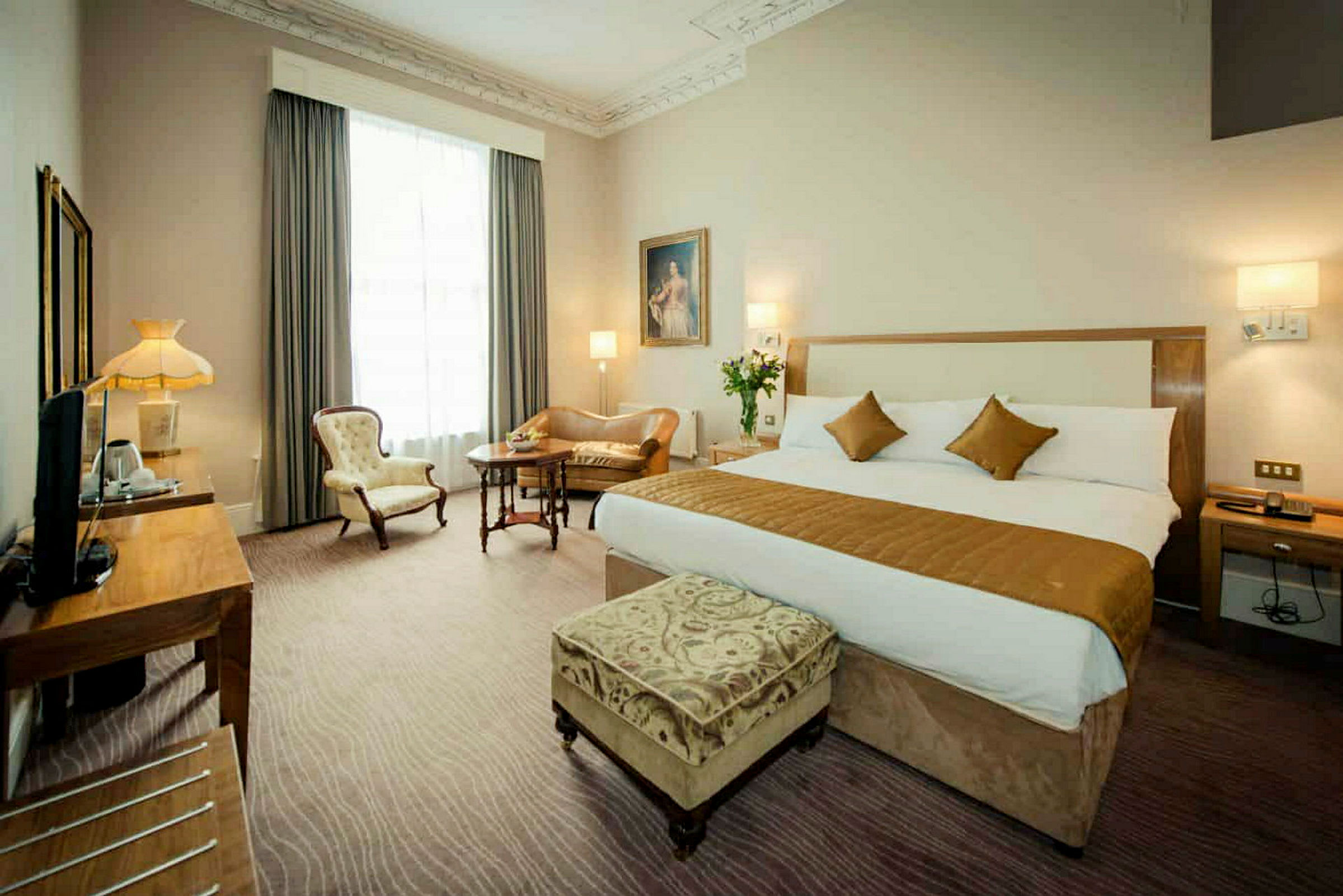 Hotellrom med stor seng og sittemøbler. (AI-generert tekst)