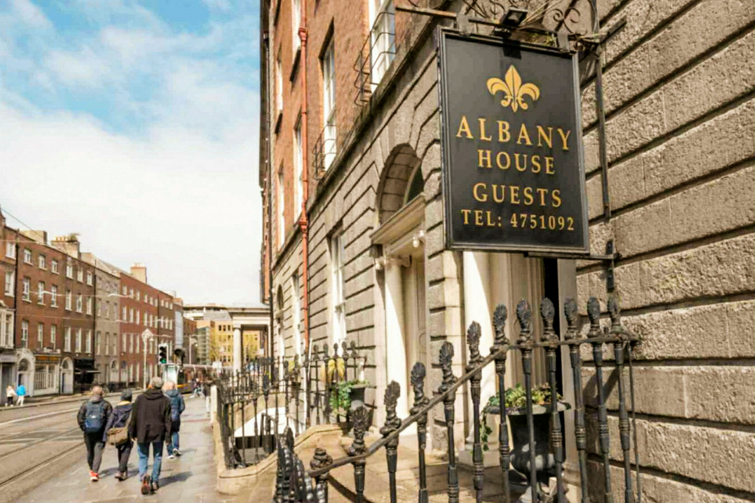 Skilt med teksten Albany House Guests ved en husfasade. (AI-generert tekst)