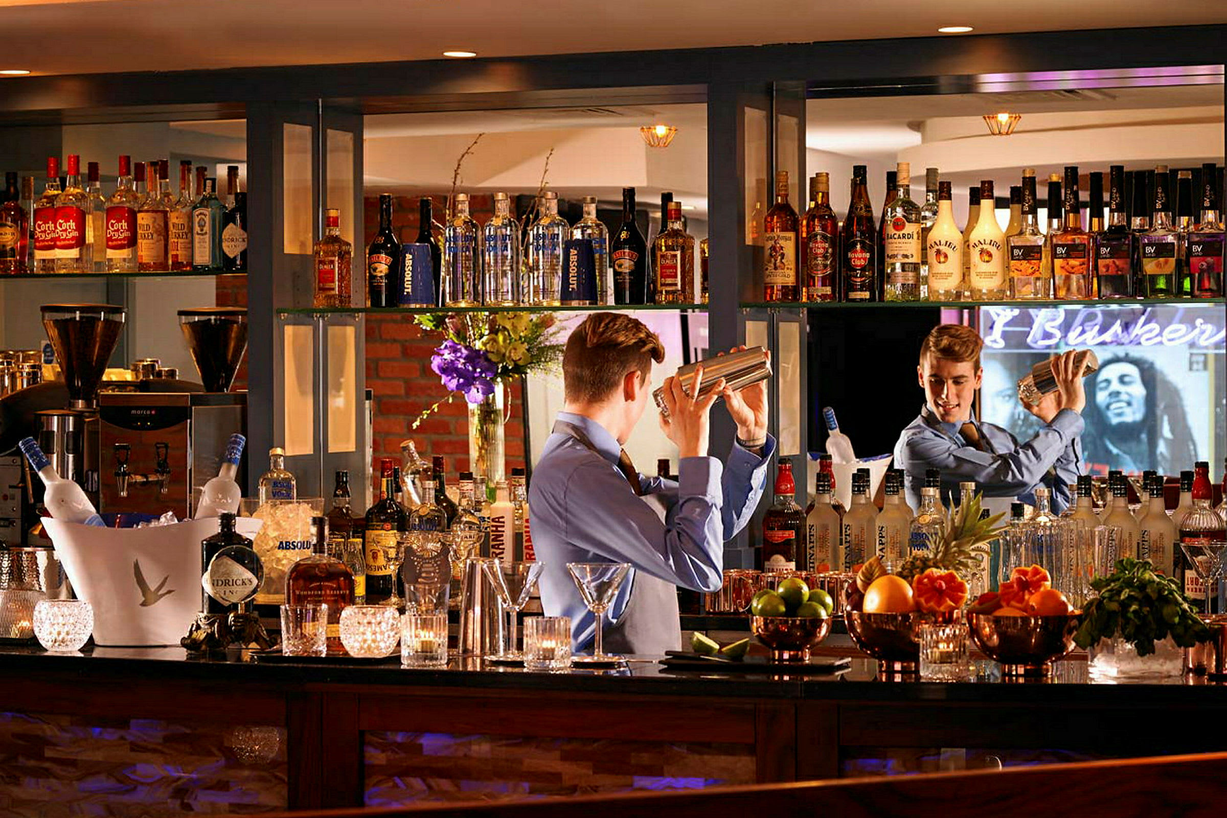 En bartender blander en cocktail bak en godt utstyrt bar. (AI-generert tekst)