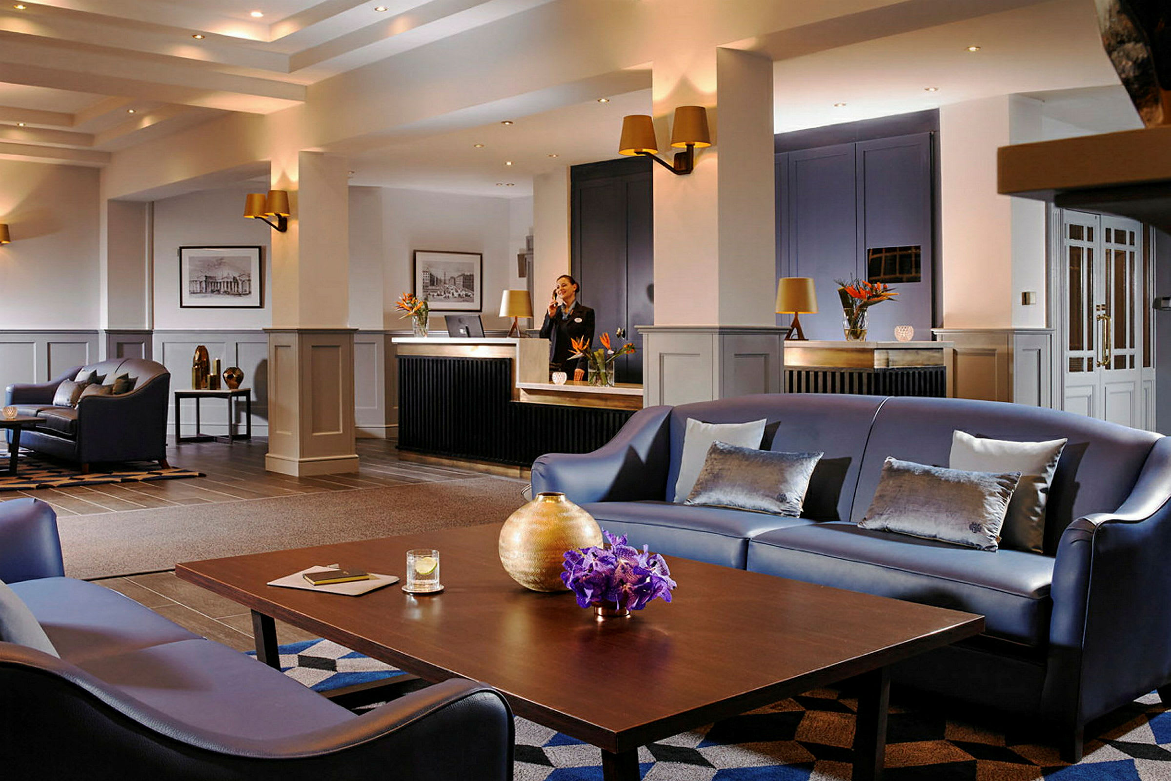 En moderne hotellobby med sofaer, bord og resepsjon. (AI-generert tekst)