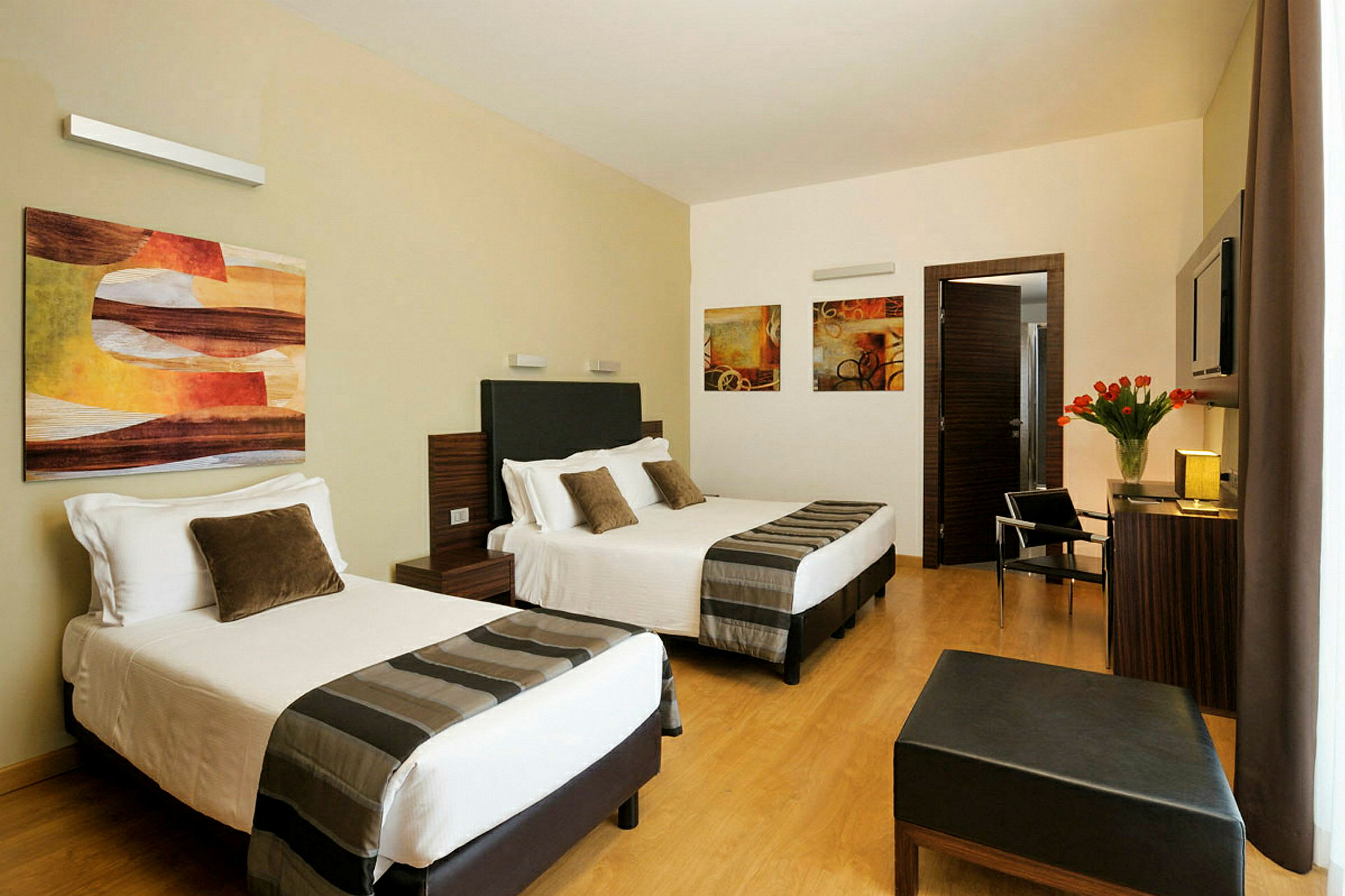 Hotellrom med to dobbeltsenger, moderne møbler og veggkunst. (AI-generert tekst)
