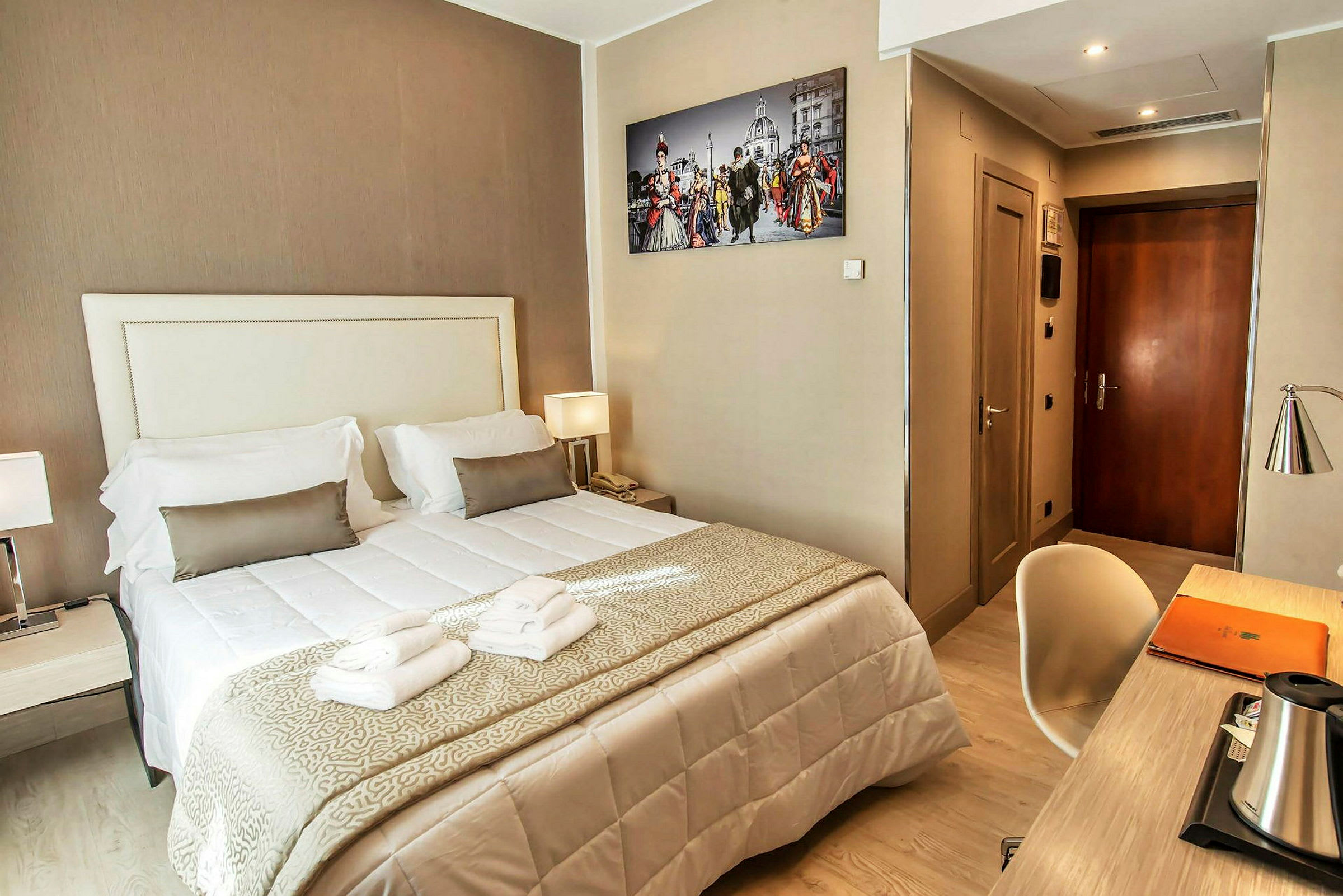 Hotellrom med dobbeltseng, skrivebord og veggfotografi. (AI-generert tekst)
