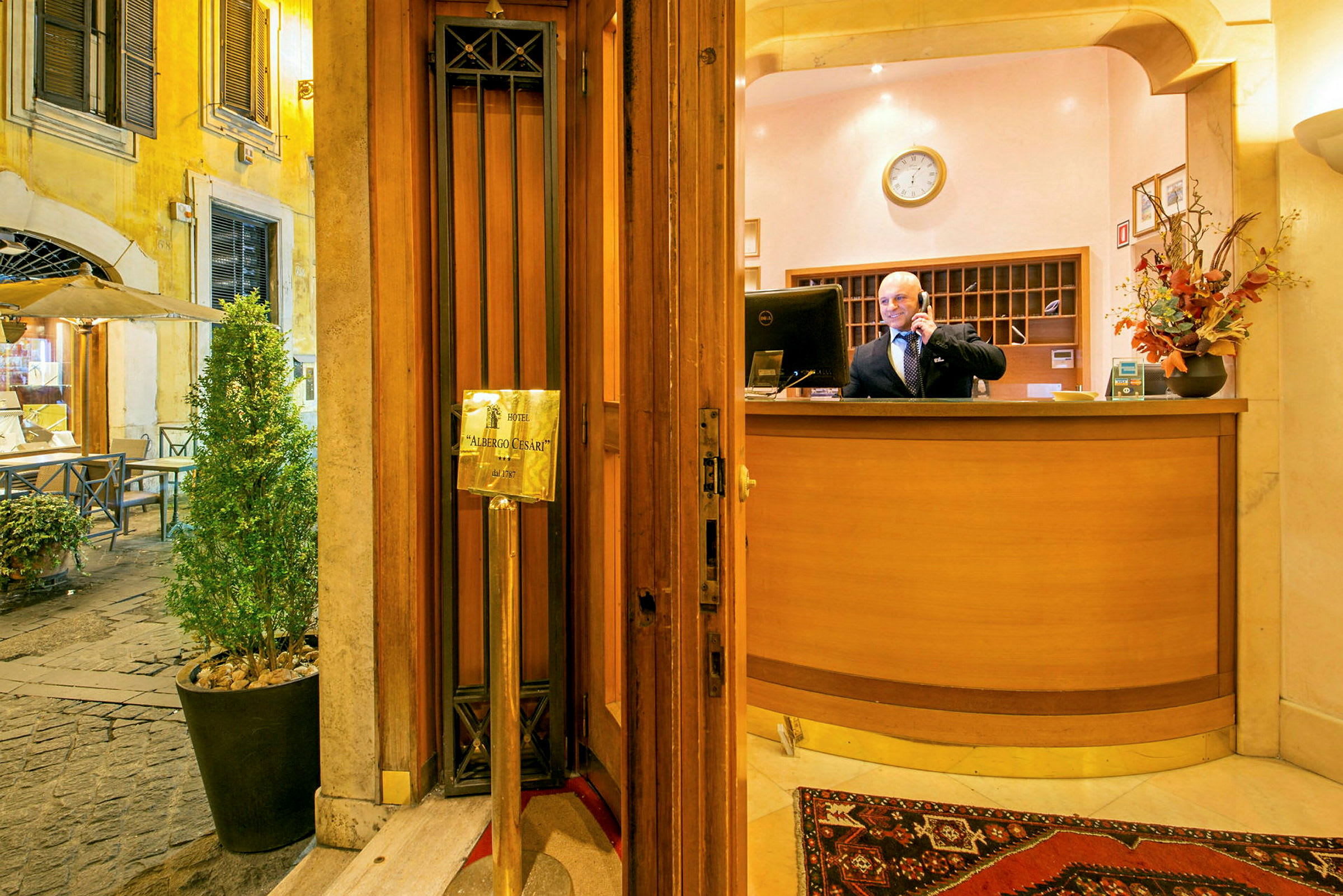 Inngangen til Hotel Albergo Cesari med resepsjonen og omgivende dekor. (AI-generert tekst)