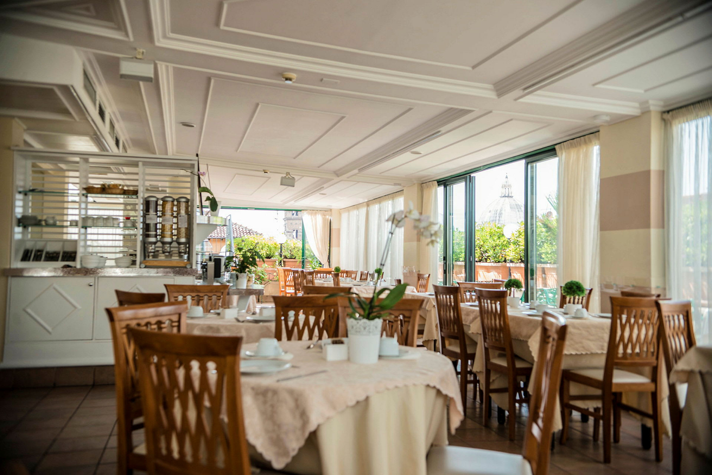 En restaurant med dekkede bord og utsikt mot en bygning med kuppel. (AI-generert tekst)