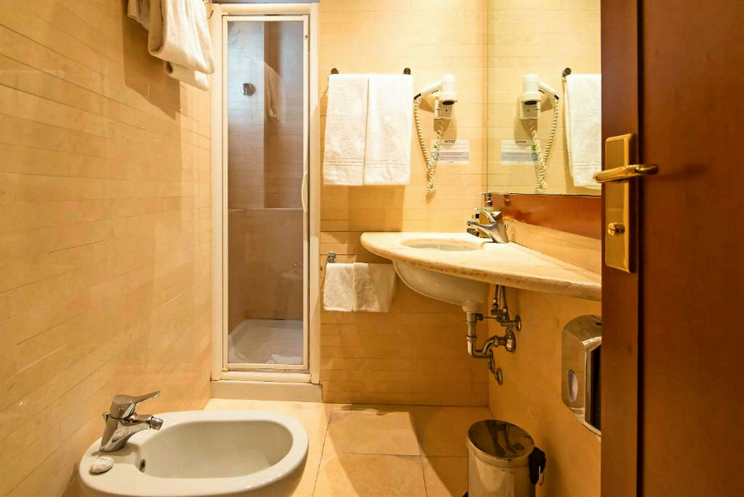 Et bad med dusj, servant, bidet og håndklær. (AI-generert tekst)