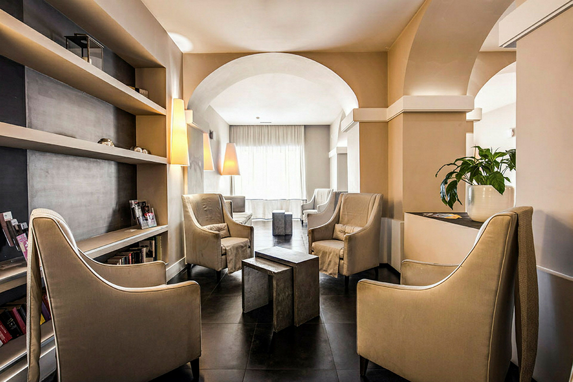 En elegant lounge med store stoler, hyller og lamper. (AI-generert tekst)