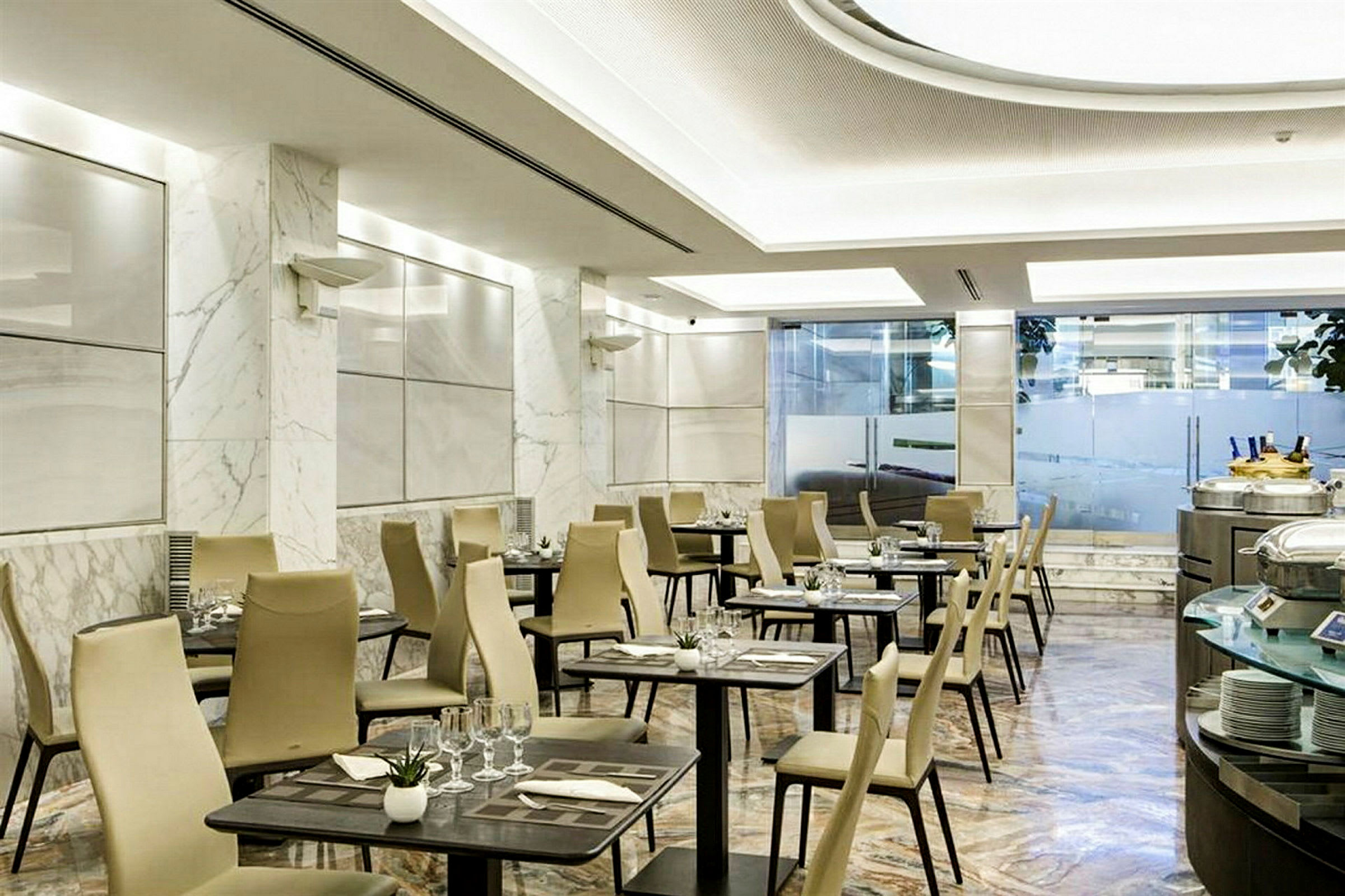 Bilde av en moderne restaurant med marmorgulv, dekkede bord og beige stoler. (AI-generert tekst)
