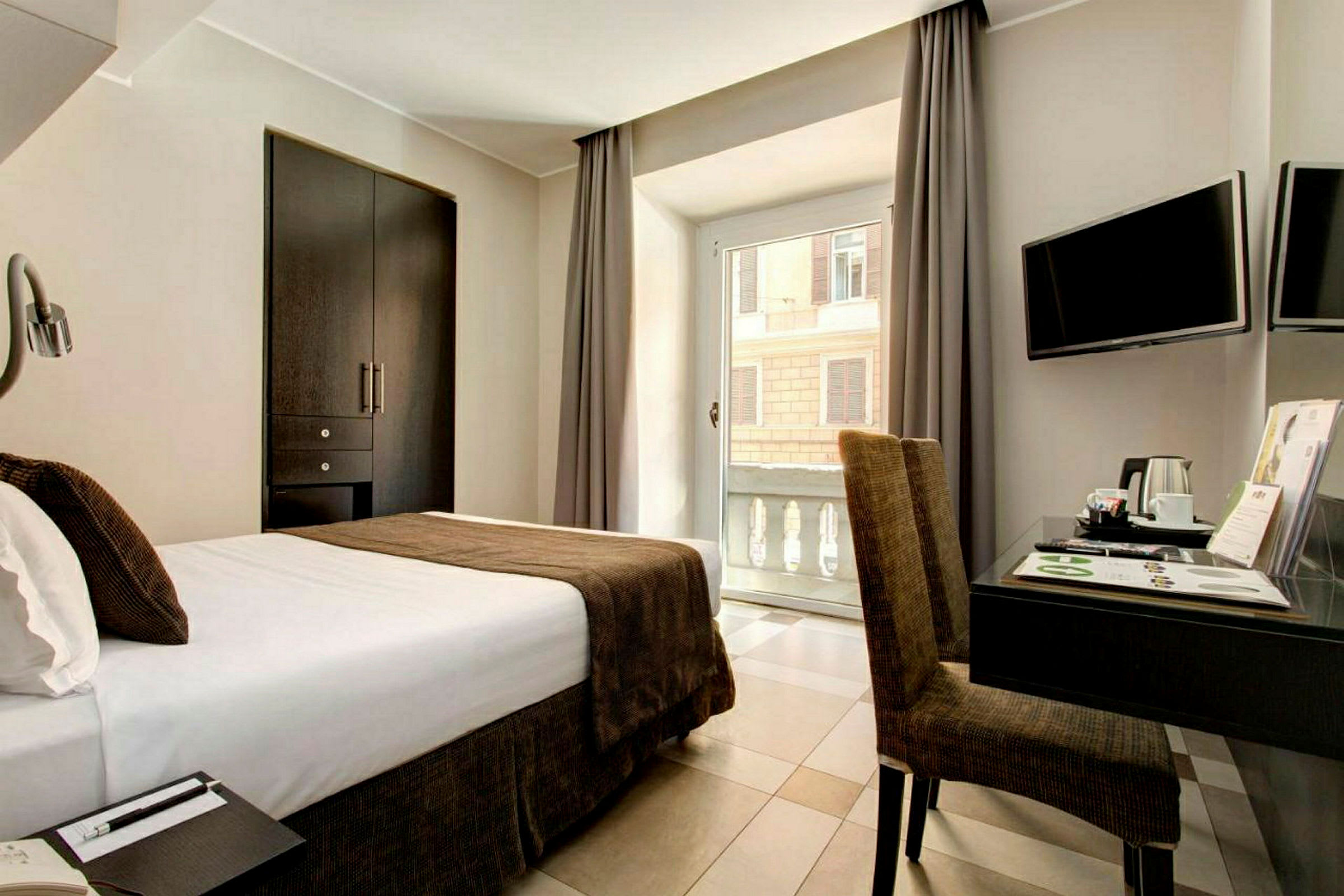 Hotellrom med seng, skrivebord og vindu med utsikt. (AI-generert tekst)
