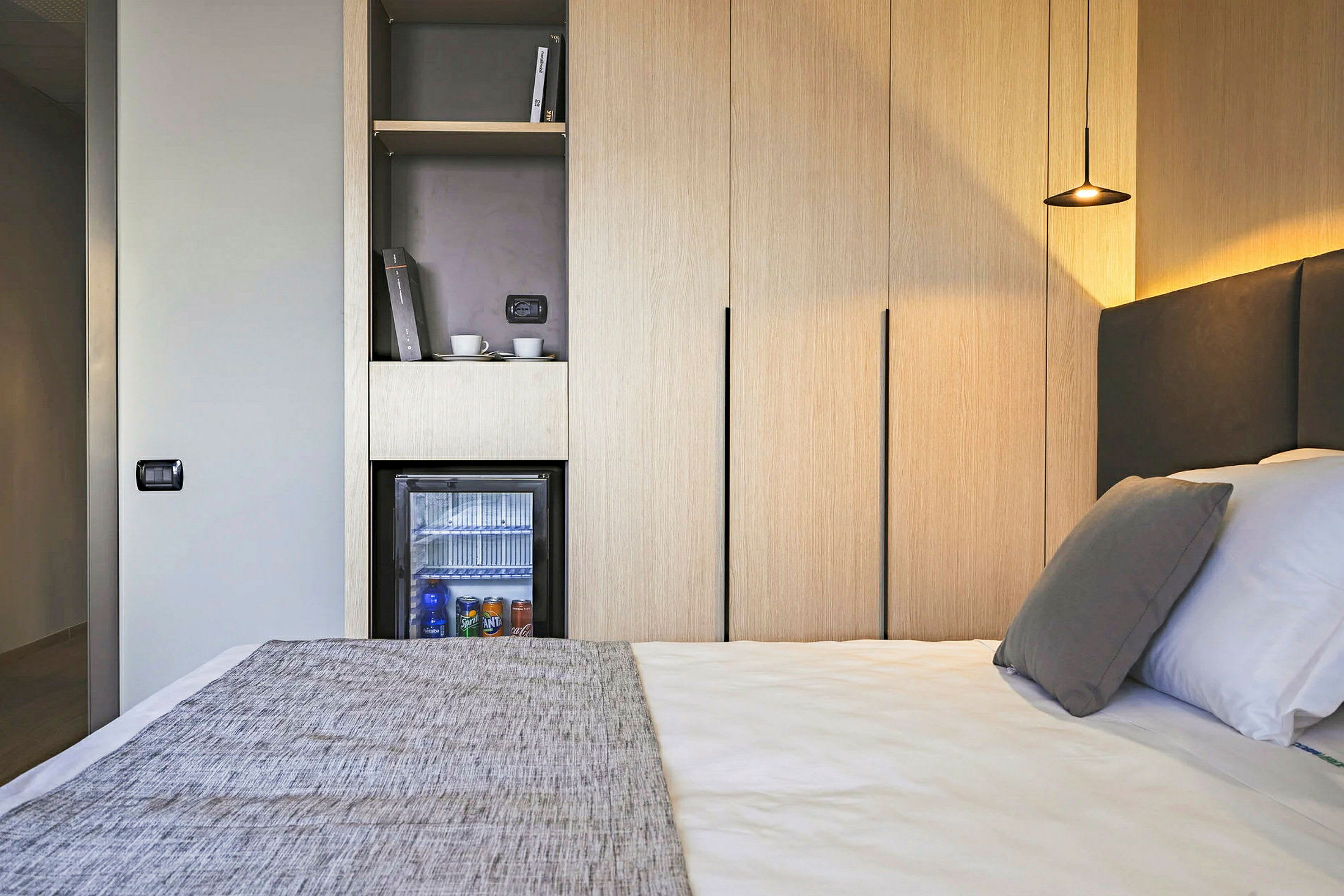 Hotellrom med seng, minibar og garderobeskap. (AI-generert tekst)