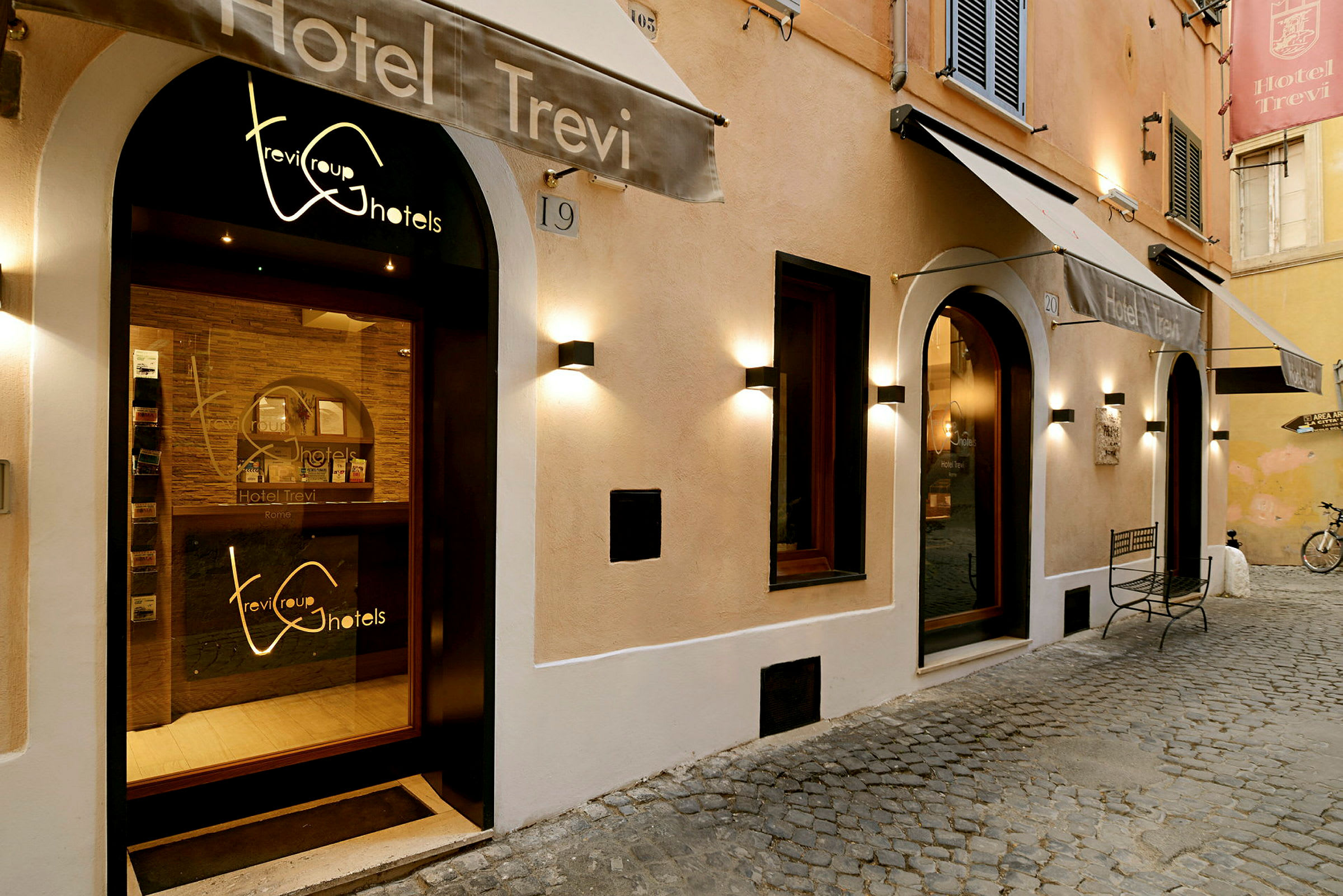Utsiden av Hotel Trevi med inngang og skilt. (AI-generert tekst)