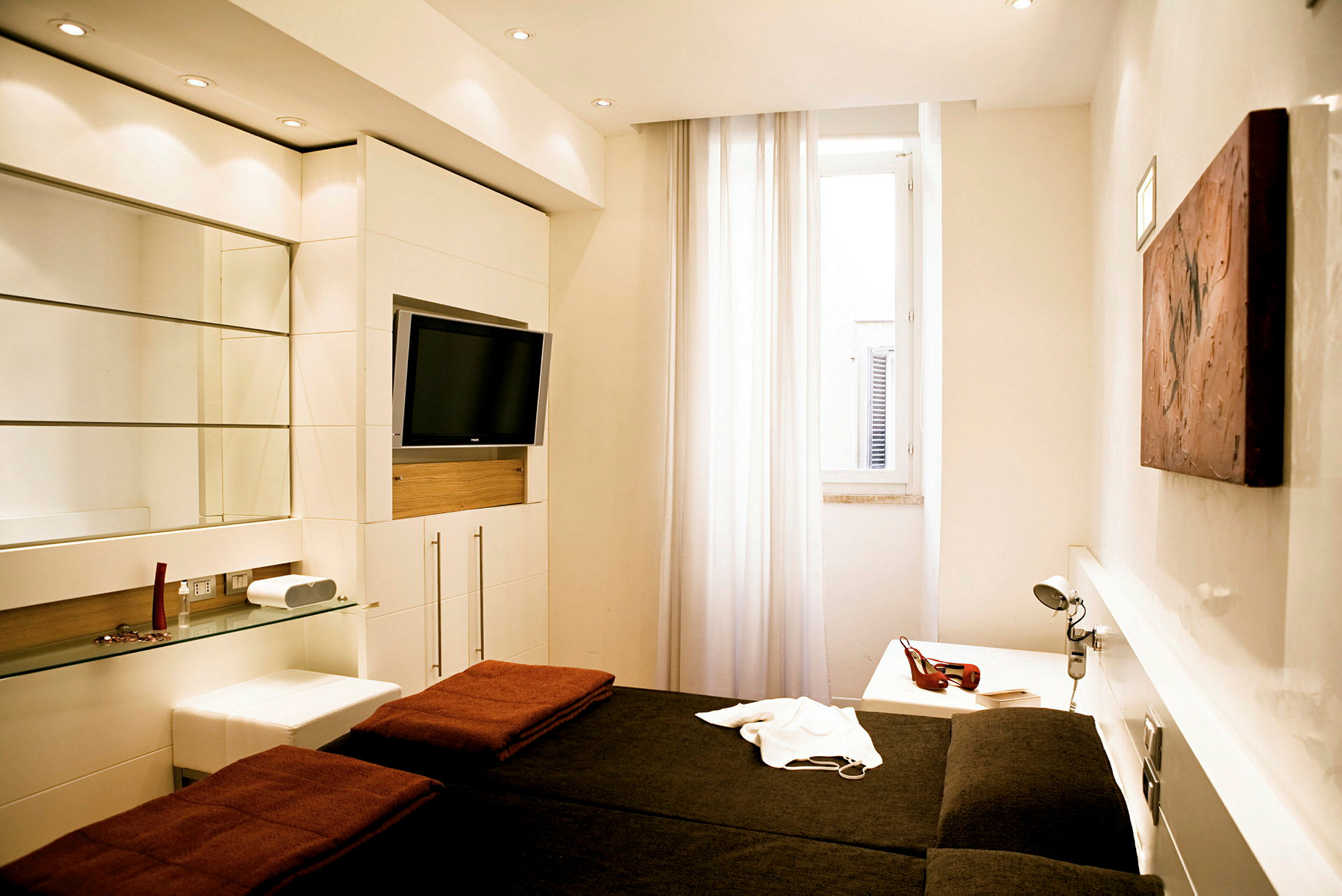 Moderne innredet hotellrom med dobbeltseng og veggmontert TV. (AI-generert tekst)