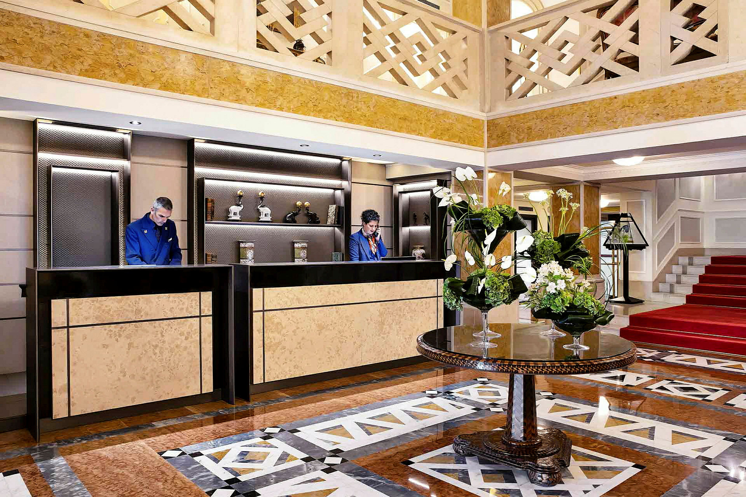 Interiør av en hotellobby med resepsjonsdisker og et bord med blomsterdekorasjoner. (AI-generert tekst)
