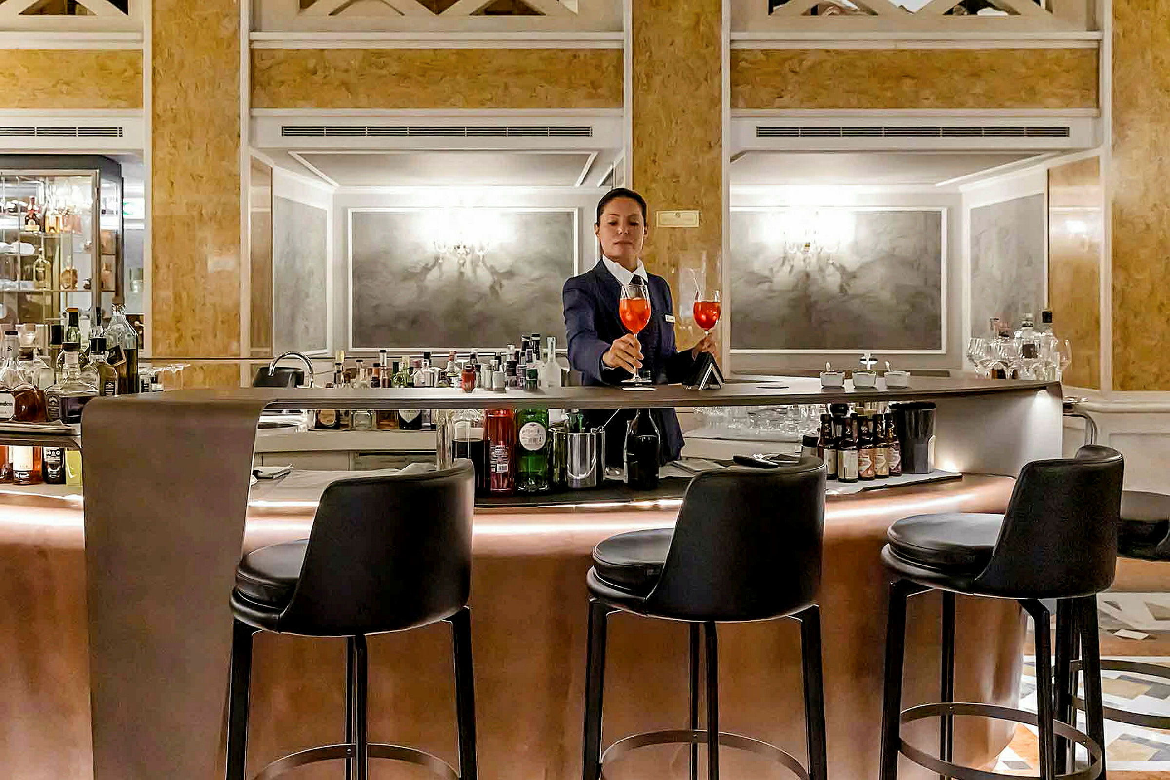 En bartender står ved en elegant bar med barkrakker rundt. (AI-generert tekst)
