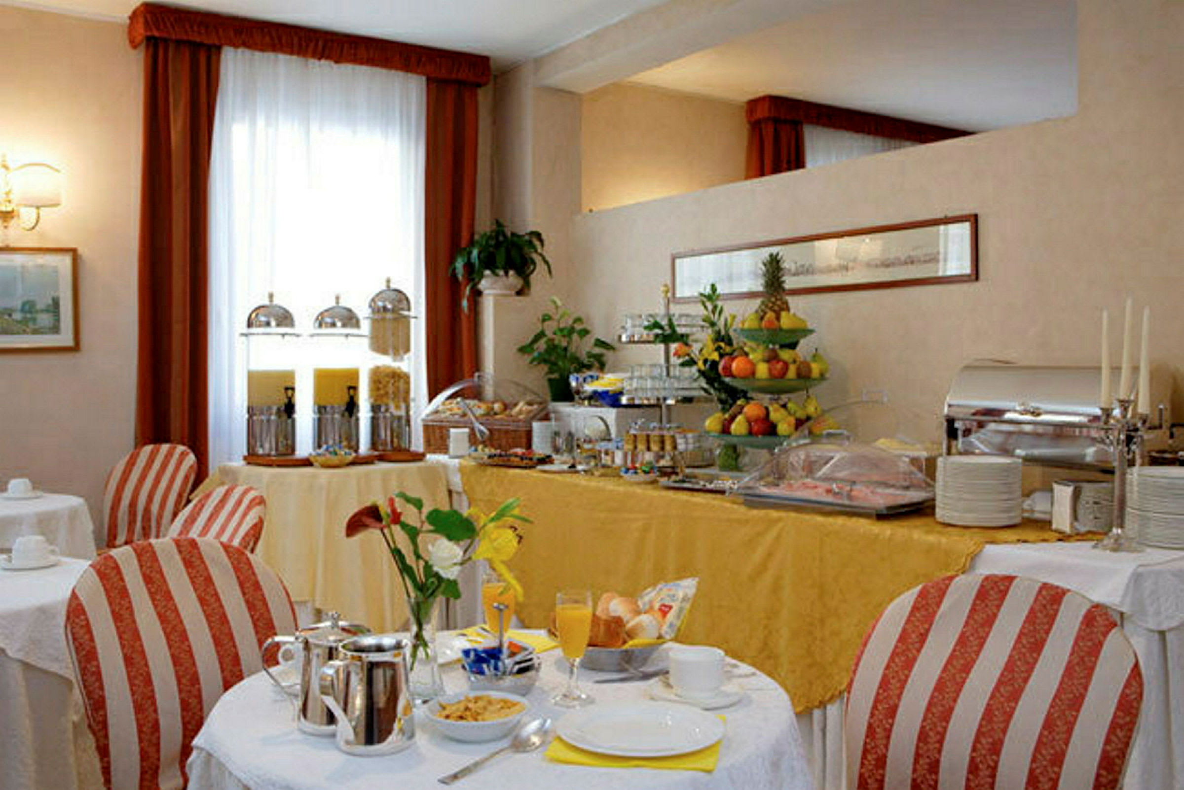 Et dekket frokostbord i en elegant spisesal med ulike frukter og drikke. (AI-generert tekst)