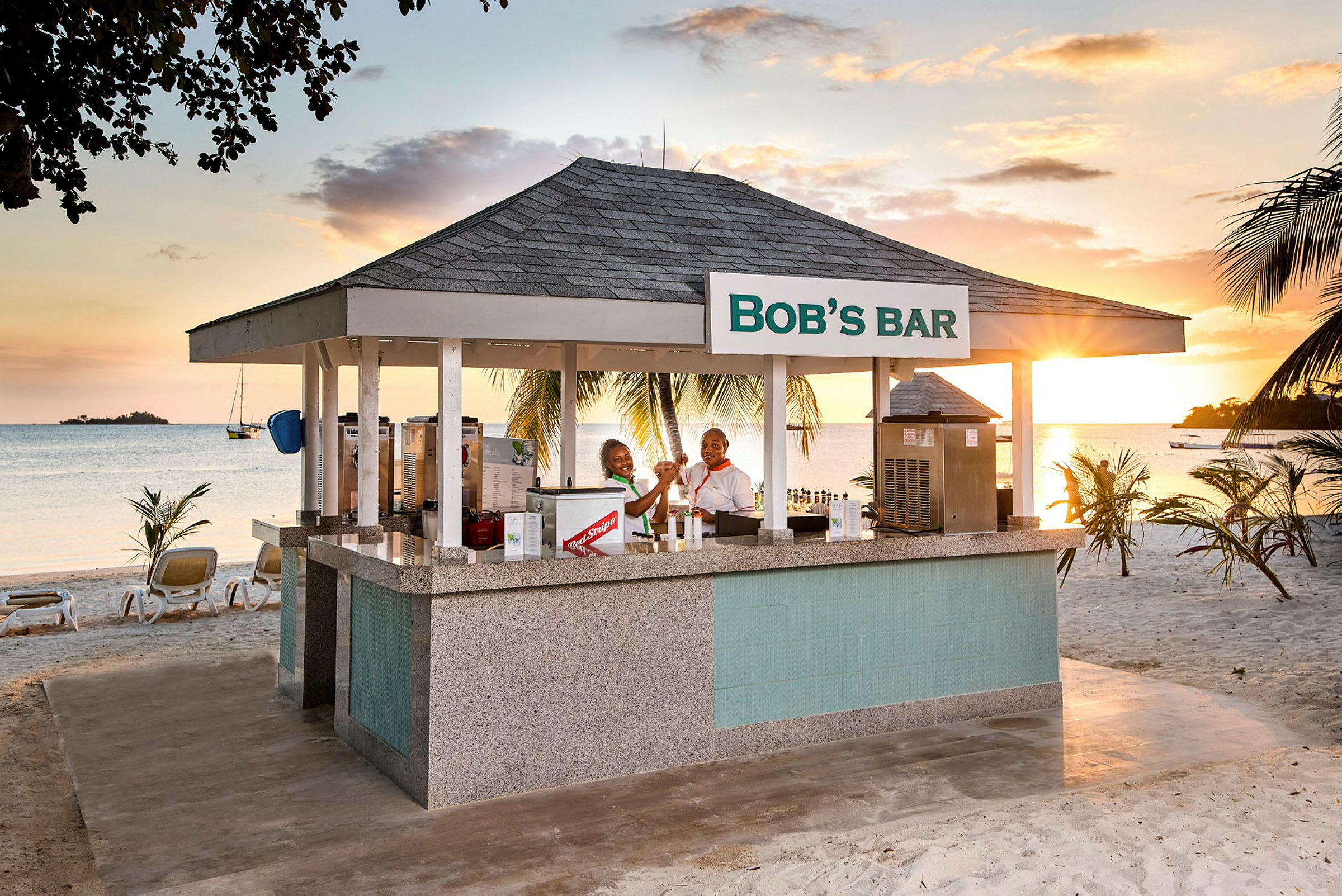 Strandbar med tak og skilt som sier 'Bob's Bar', omgitt av palmer og med havutsikt. (AI-generert tekst)