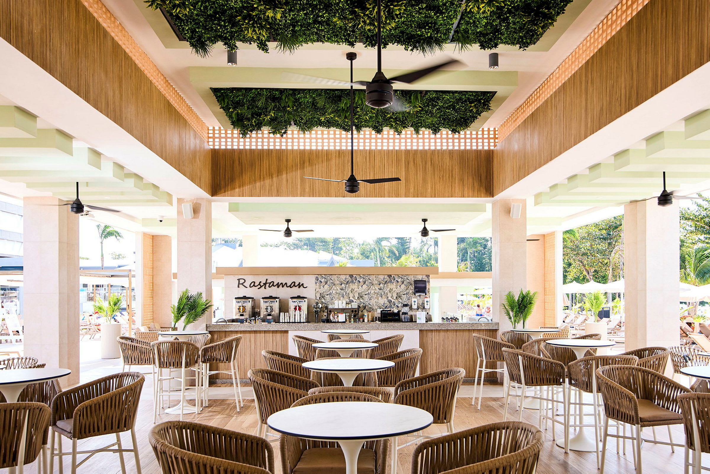 Restaurant med sitteområder og en bardisk dekorert med grønne planter. (AI-generert tekst)