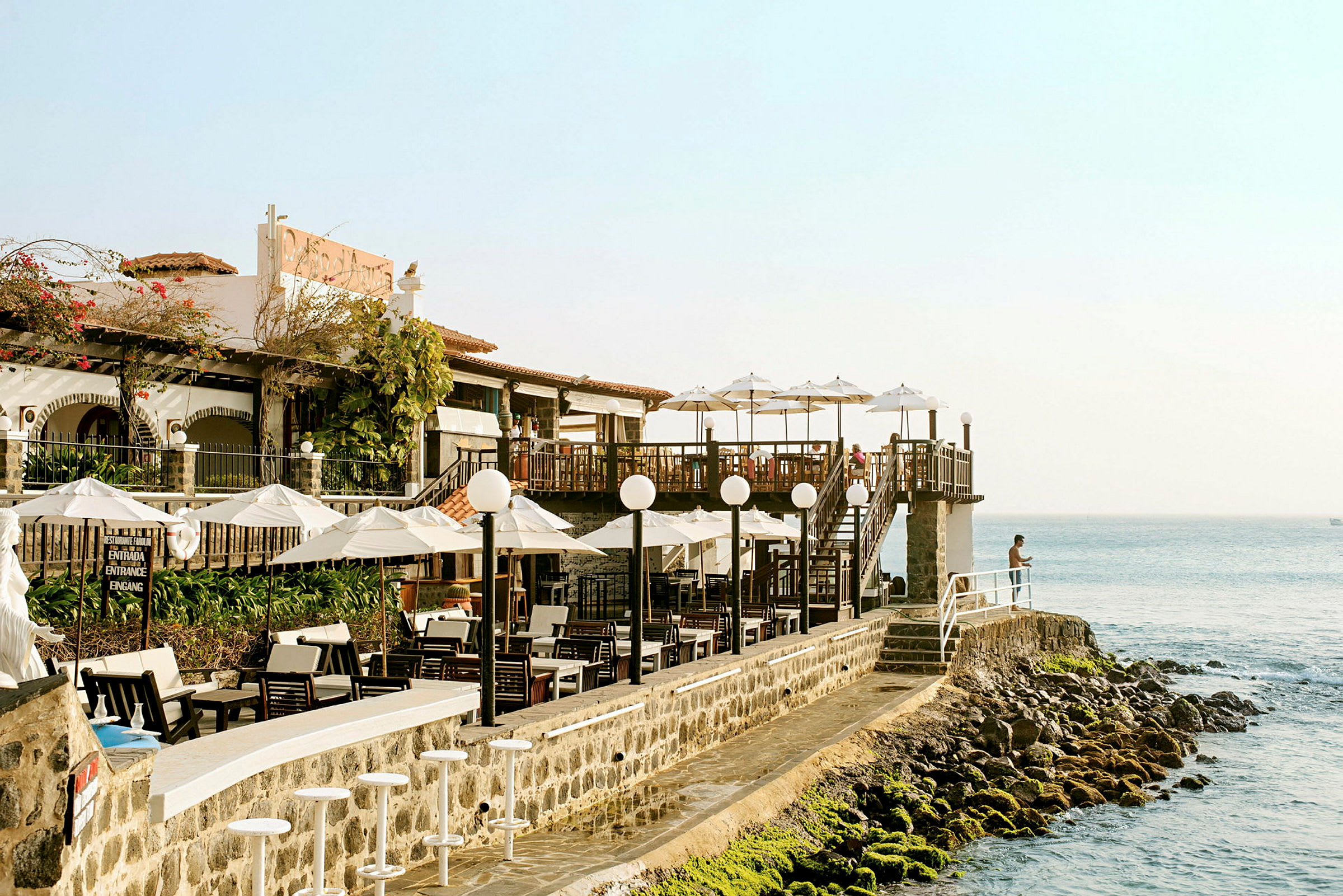Restaurant ved vannet med utsikt over havet. (AI-generert tekst)