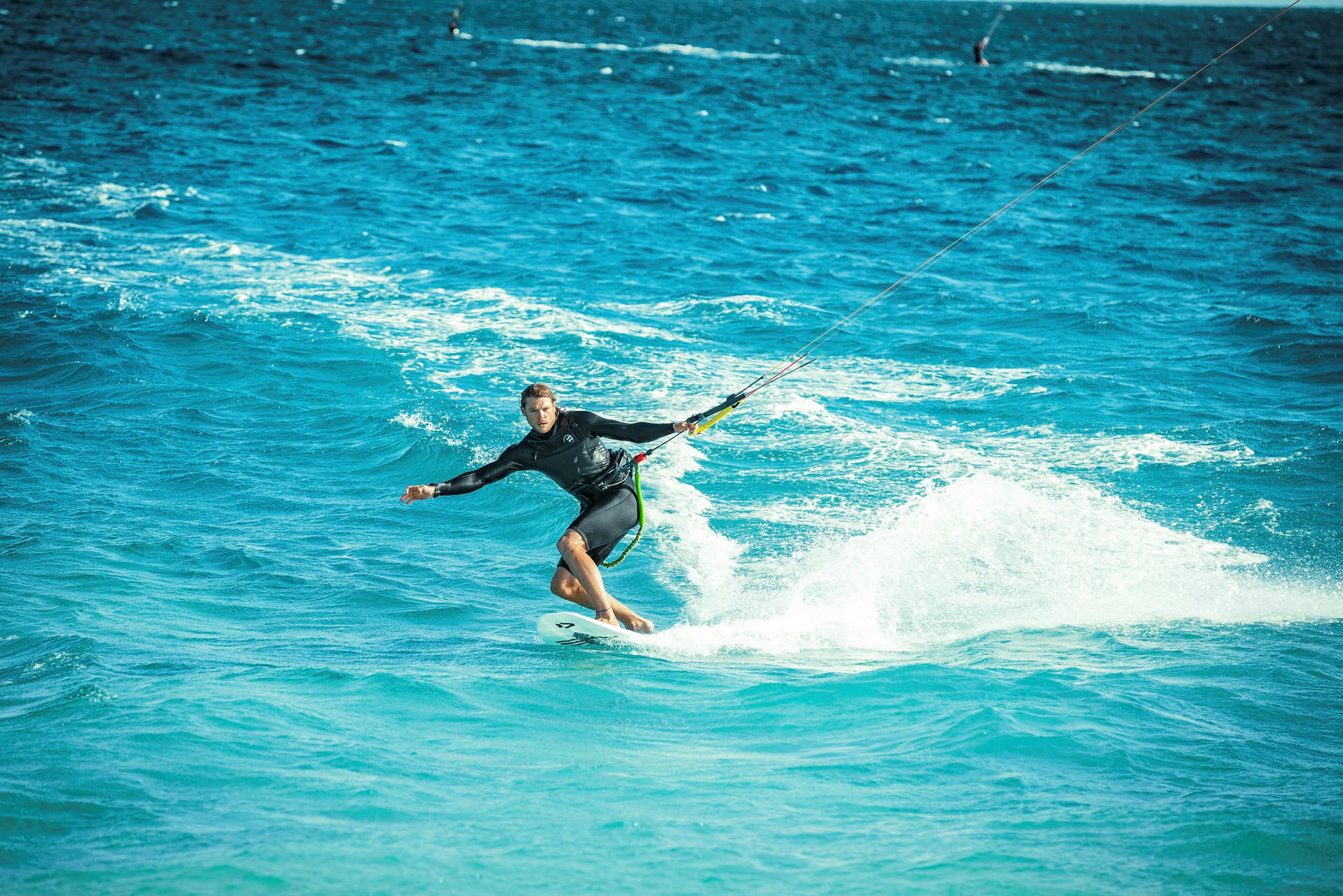 Person som driver med kitesurfing på et blått hav. (AI-generert tekst)