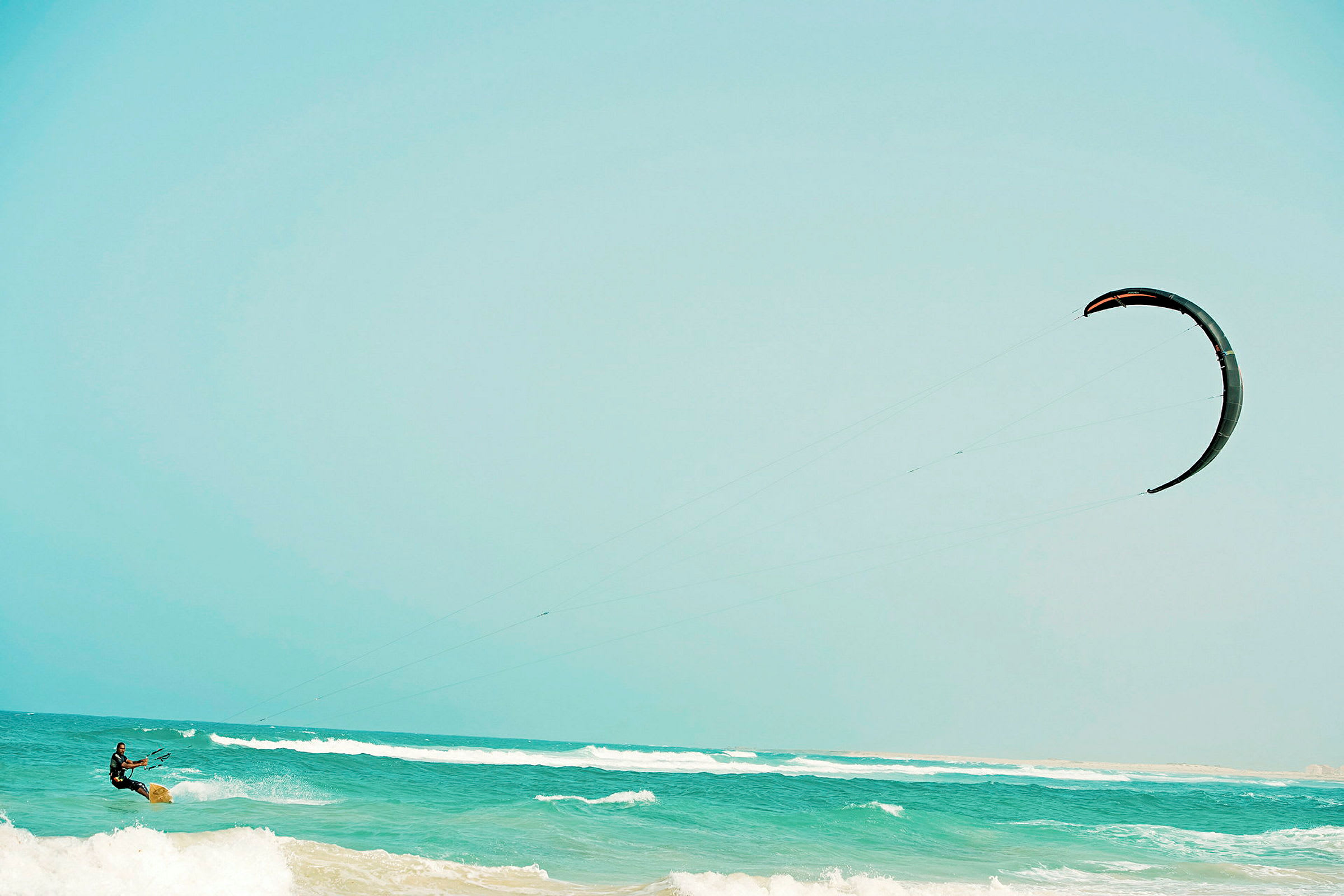 En person driver med kitesurfing på havet. (AI-generert tekst)